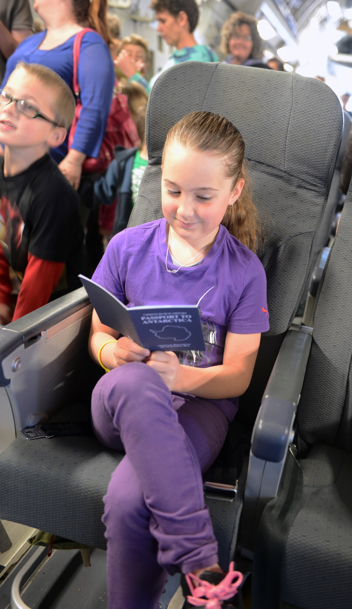 A young New Zealand girl looks through her IceFest 2014 passport while waiting for an opportunity to visit the flight deck of the C-17 Globemaster III, Oct. 5th, 2014 as part of the U.S. Antarctic Program Day for IceFest 2014 at Christchurch, New Zealand. More than 7,000 community members visited the C-17 throughout the day. (U.S. Air Force photo/Master Sgt. Todd Wivell)
