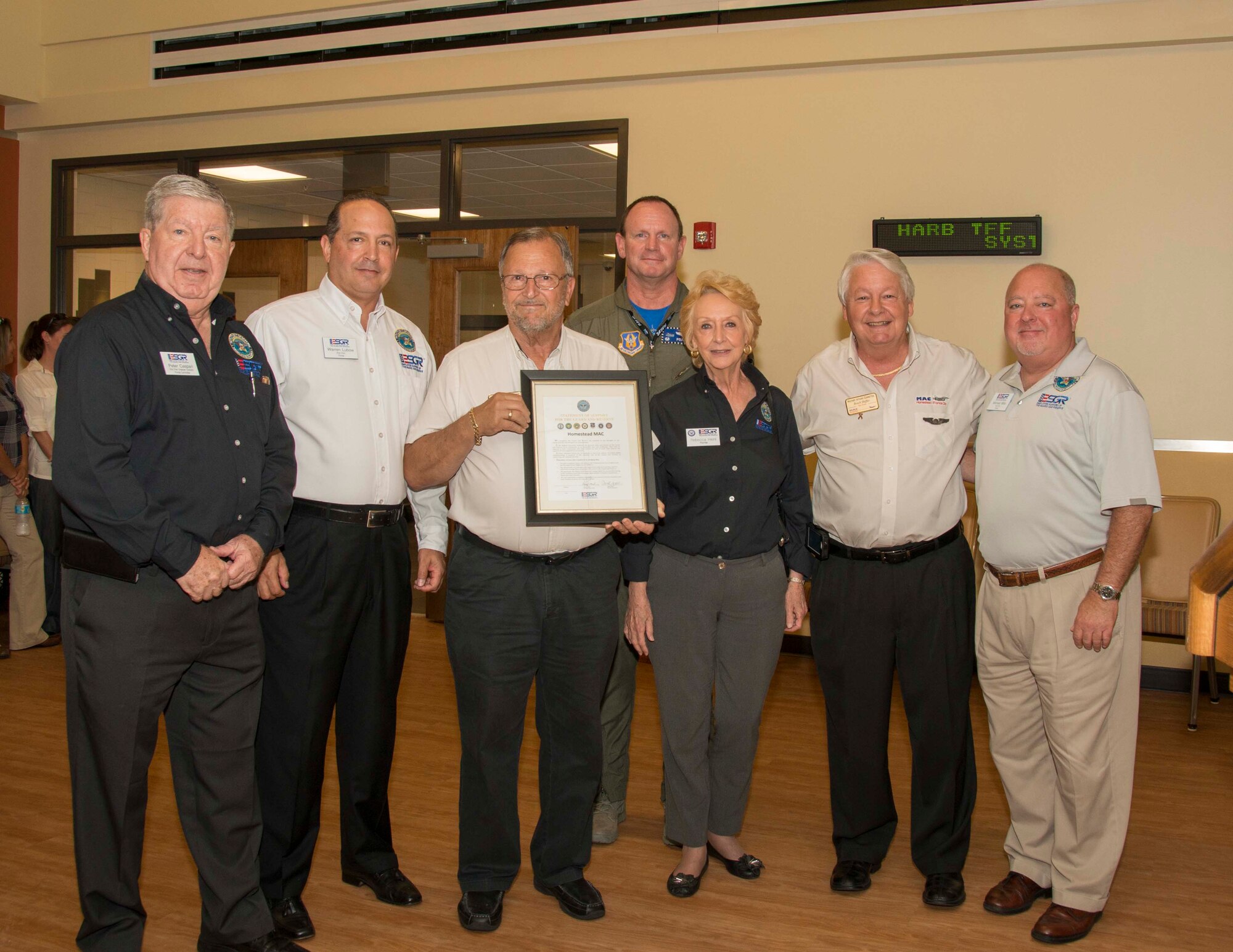 Members from the Employer Support of the Guard and Reserve team, the Military Affairs Committee, and Col. Chris Funk, 482nd Fighter Wing commander at Homestead Air Reserve Base, Fla., pose for a group photo along with a gift presented to the MAC by the ESGR for the support the MAC has shown to the service members in the area at the Community Activity Center on Homestead ARB Oct. 3. The presentation was made during a MAC meet and greet, held in honor of the wing, which is one of the many events held by the MAC for military members. (U.S. Air Force photo by Senior Airman Jaimi L. Upthegrove)