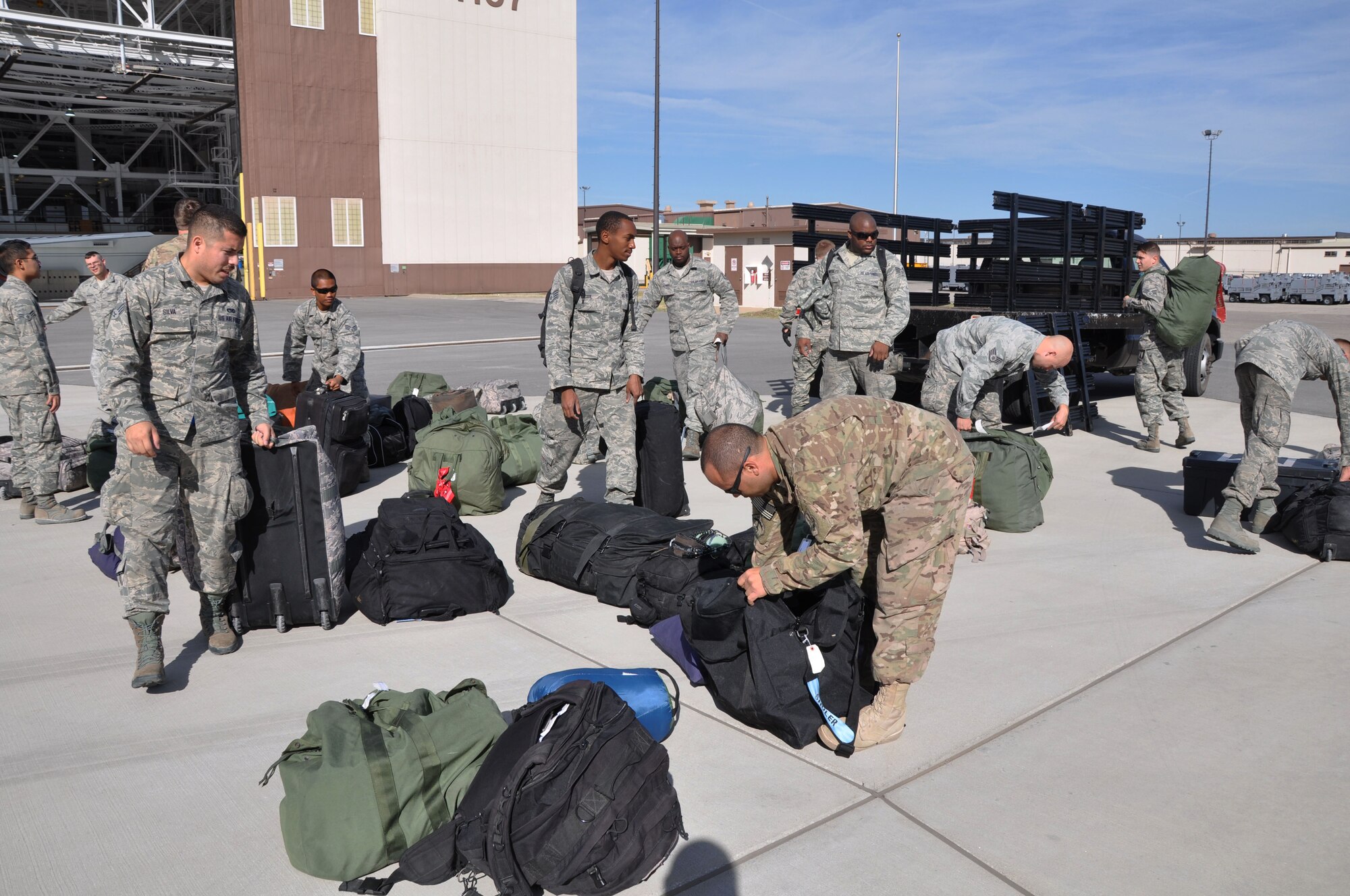 Members of the 931st Air Refueling Group unload their bags after returning from a deployment to Southwest Asia Oct. 4, 2014, McConnell Air Force Base, Kan. After members of the 931st Aircraft Maintenance Squadron and 931st Operations Supports Squadron successfully launched nine KC-135s in thirty-second intervals during the October Unit Training Assembly, two aircraft landed at Forbes Field, Kan., and returned deployers to McConnell.  (U.S. Air Force photo by Staff Sgt. Abigail Klein)