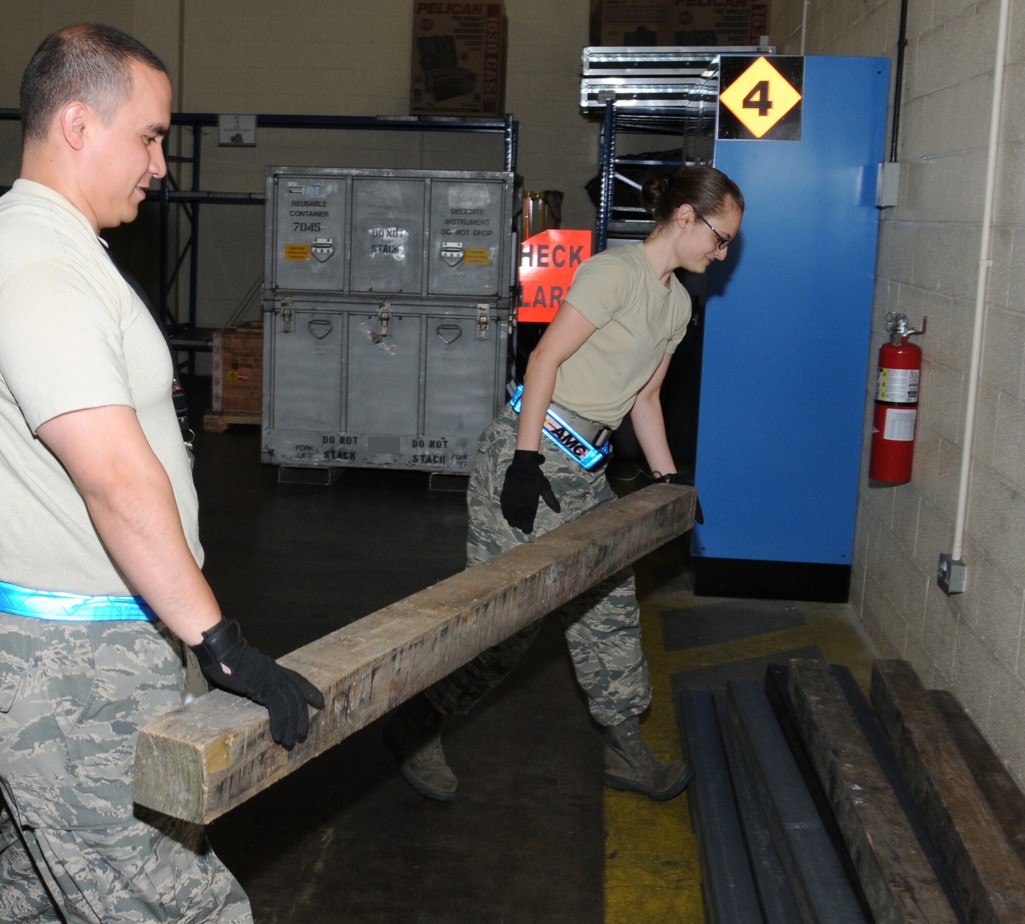U.S. Air Force Senior Airman Felicia Zimmer, right, 727th Air Mobility Squadron Air Freight specialist from Nashville, Tenn., and U.S. Air Force Tech. Sgt. David Owens, 727th AMS NCO in charge of the Air Terminal Operations Center from Panama City, Fla., move pieces of dunnage following the collection of a pallet they were supporting Sept. 2, 2014, in the freight terminal on RAF Mildenhall, England. Pallets are stored off the ground so a forklift can pick up the pallet safely. (U.S. Air Force photo/Gina Randall/Released)