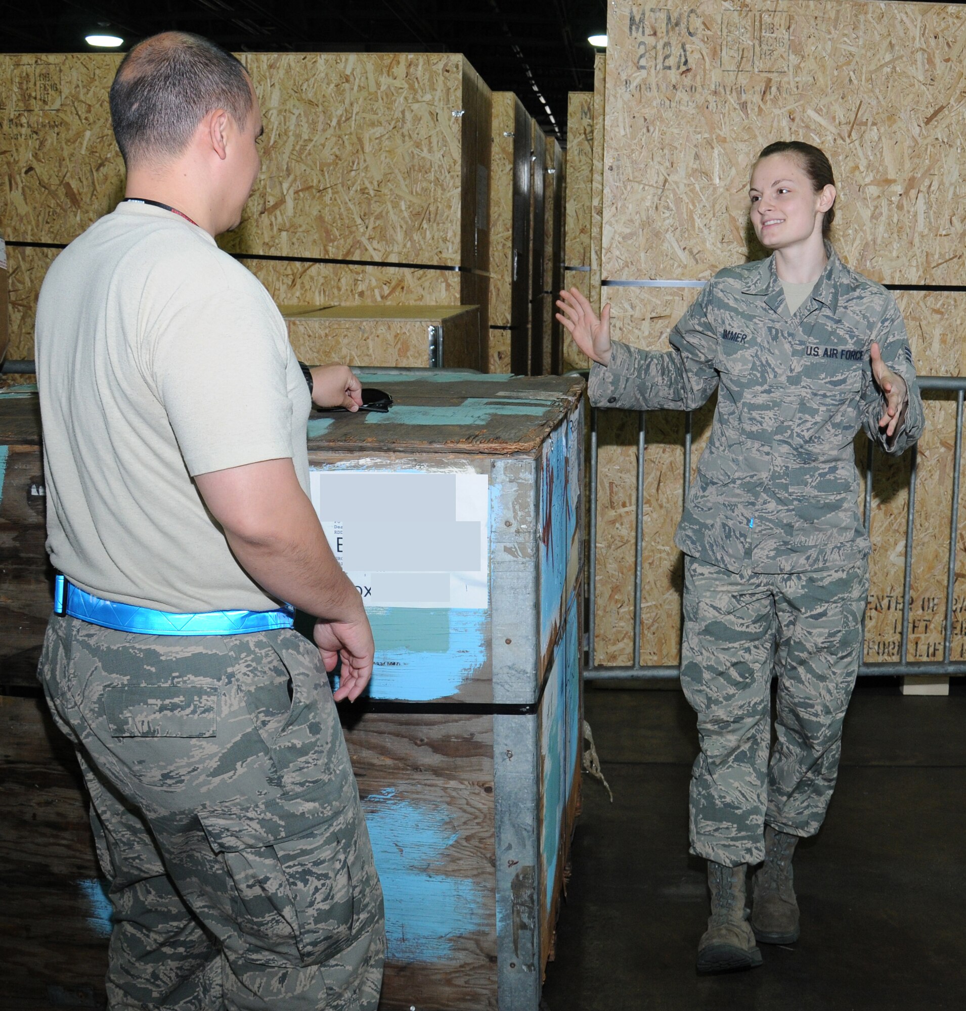 U.S. Air Force Senior Airman Felicia Zimmer, right, 727th Air Mobility Squadron Air Freight specialist from Nashville, Tenn., and U.S. Air Force Tech. Sgt. David Owens, 727th AMS NCO in charge of the Air Terminal Operations Center from Panama City, Fla., discuss procedures to ensure cargo reaches its destination Sept. 2, 2014, in the freight terminal on RAF Mildenhall, England. Cargo must be correctly packaged and documented whenever it leaves from or arrives to RAF Mildenhall. (U.S. Air Force photo/Gina Randall/Released)
