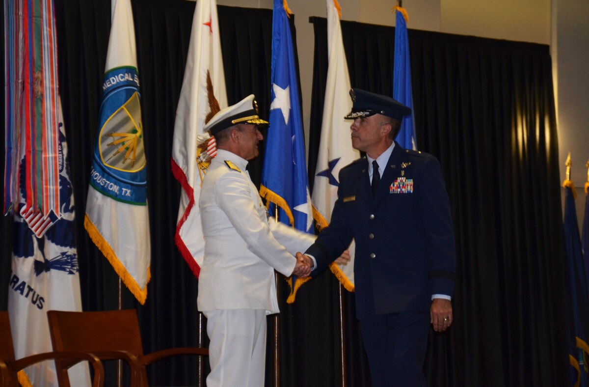 Rear Adm. William Roberts congratulates Brig. Gen. Robert Miller on relieving him as the new Medical Education and Training Campus commandant during a Change of Commandant ceremony September 24. Miller is METC's first Air Force commandant, a position that also inherits the dual hat of Education & Training (E&T) director for  the new Defense Health Agency.  Lt. Gen. Douglas Robb, Director of the Defense Health Agency, presided over the ceremony while the Honorable Dr. Jonathan Woodson, Assistant Secretary of Defense for Health Affairs, served as guest speaker (Photo by Lisa Braun)