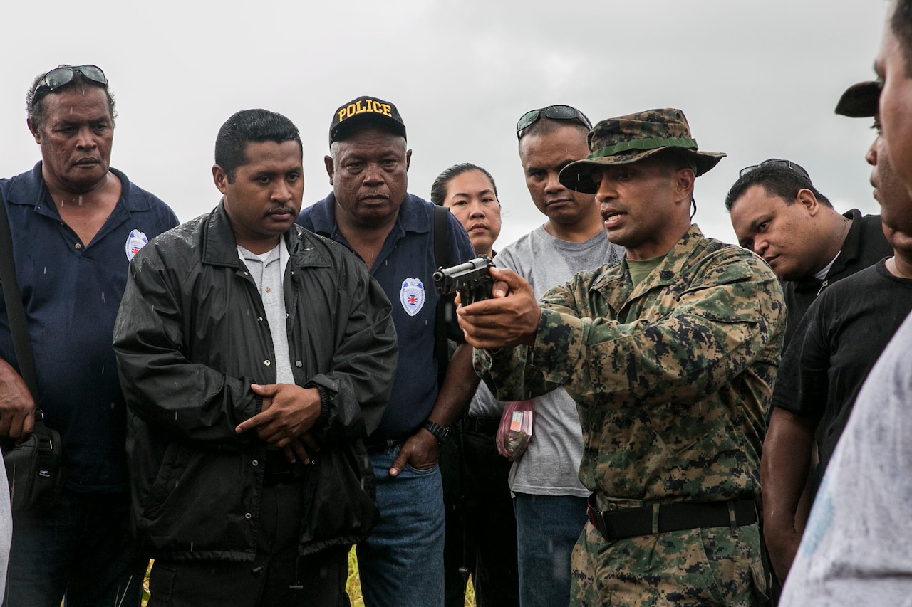 Marine Corps Staff Sgt. Milton Donatus, second from right, instructs Palau national law enforcement officers on the operations of the M9A1 9 mm service pistol in Irai, Palau, Sept. 16, 2014. Donatus is a native of Ngaraard, Palau. U.S. Marine Corps photo by Lance Cpl. Drew Tech