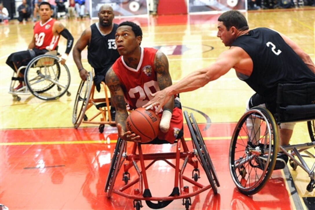 Marine Corps Sgt. Anthony McDaniel Jr., left, evades an Army defender as he moves toward the basket during the wheelchair basketball gold medal game at the Warrior Games in Colorado Springs, Colo., Oct. 3, 2014. The Marine Corps team won the game, 42-21. More than 200 wounded, ill and injured service members and veterans competed in the Warrior Games at the U.S. Olympic Training Center. 