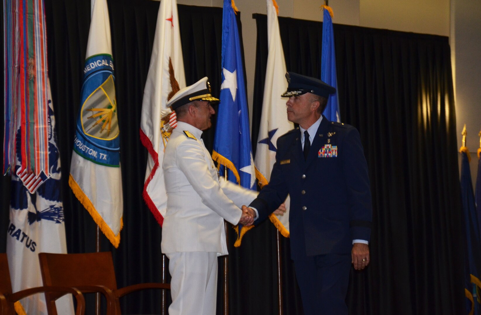Rear Adm. William Roberts congratulates Brig. Gen. Robert Miller on relieving him as the new Medical Education and Training Campus commandant during a Change of Commandant ceremony September 24. Miller is METC's first Air Force commandant, a position that also inherits the dual hat of Education & Training (E&T) director for  the new Defense Health Agency.  Lt. Gen. Douglas Robb, Director of the Defense Health Agency, presided over the ceremony while the Honorable Dr. Jonathan Woodson, Assistant Secretary of Defense for Health Affairs, served as guest speaker 
(Photo by Lisa Braun)
