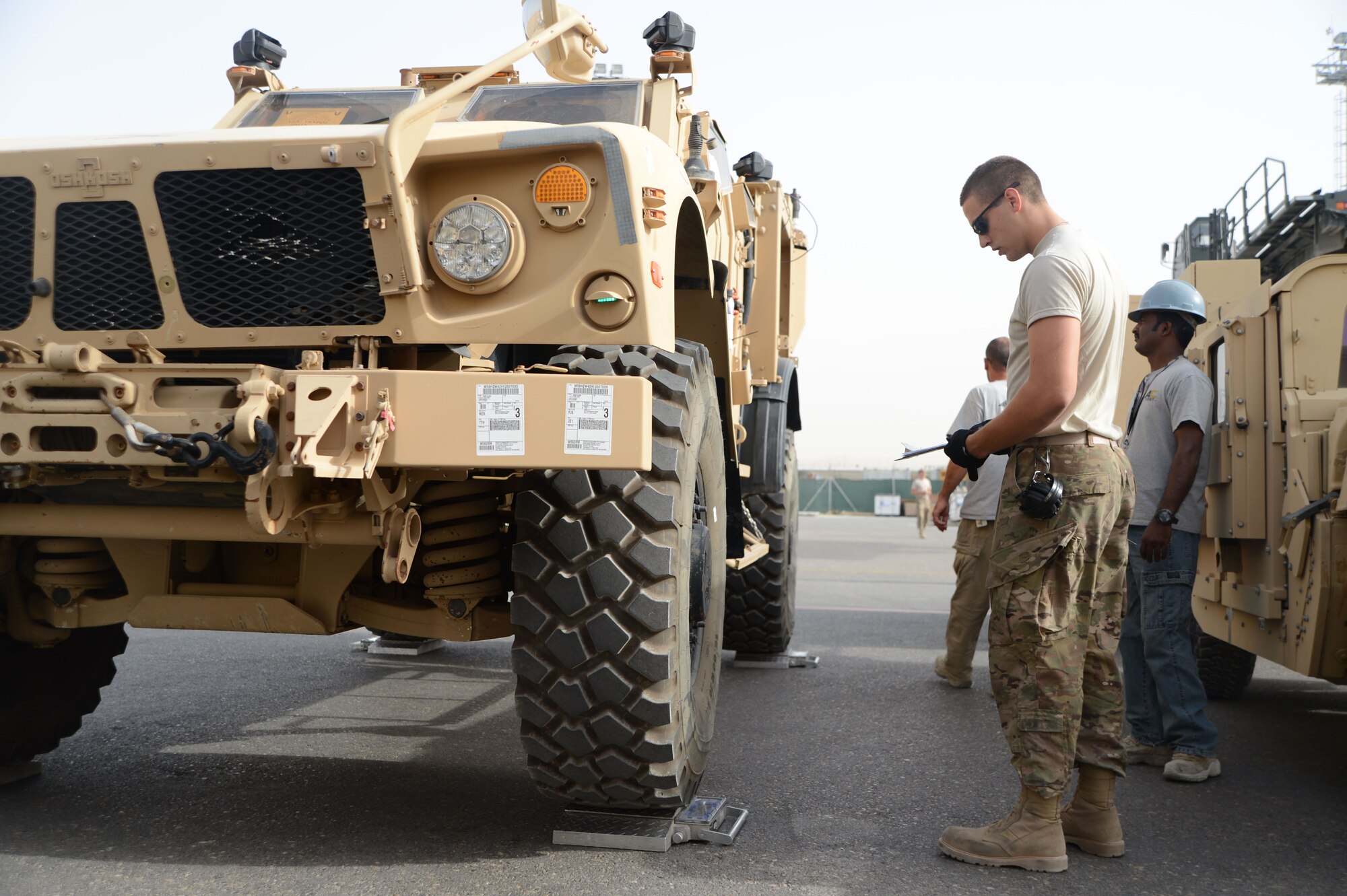 U.S. Air Force Tech. Sgt. Chaz Jensby, a night shift supervisor assigned to the 455th Expeditionary Aerial Port Squadron Detachment 1, checks the weight of the front driver side axel of a Mine Resistant Ambush Protected All-Terrain Vehicle as part of inspection procedures at Mazar-e Sharif, Afghanistan June 24, 2014. Before accepting vehicles for shipment, Jensby is responsible for ensuring the weight matches the shipping paperwork and the vehicles are cleaned. If these aren’t done, the vehicle is returned to the customer. Jensby, a native of Lincoln, Neb., is a reservist deployed from the 155th Air Refueling Wing, Lincoln, Neb. (U.S. Air Force photo by Master Sgt. Cohen A. Young/Released)  
