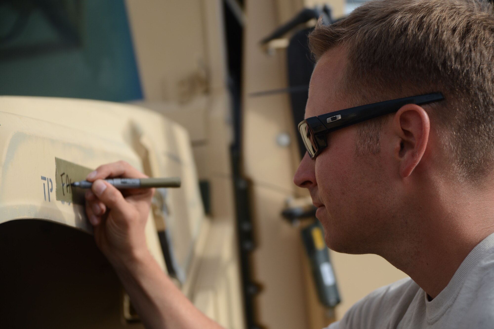 U.S. Air Force Staff Sgt. Michael Middleton, a cargo processor assigned to the 455th Expeditionary Aerial Port Squadron Detachment 1, writes the weight of front driver side axel of an up-armored Humvee during the inspection process of accepting vehicles for shipment Sept. 24 on the flight line of at Mazar-e Sharif, Afghanistan June 24, 2014. Middleton, a native of Bonney Lake, Wash., is deployed from the 732nd Air Mobility Squadron at Joint Base Elmendorf-Richardson, Alaska. (U.S. Air Force photo by Master Sgt. Cohen A. Young/Released)  