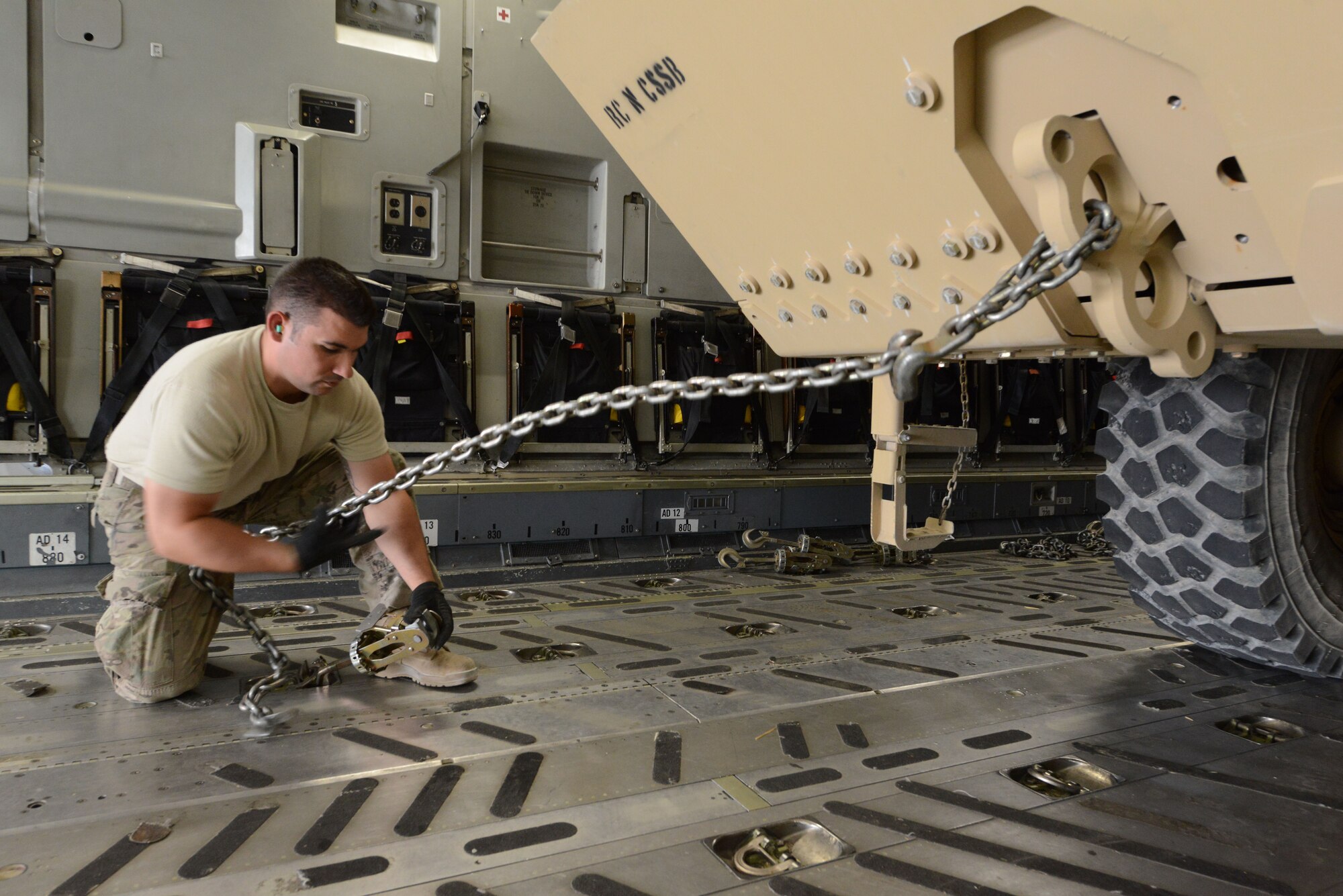 U.S. Air Force Staff Sgt. Reuben Montes, an air transportation journeyman assigned to the 455th Expeditionary Aerial Port Squadron Detachment 1, uses chains to lock a Heavy Expanded Mobility Tactical Truck into place aboard a C-17 Globemaster III while at Mazar-e Sharif, Afghanistan June 24, 2014. As part of the retrograde mission, EAPS Det 1 is responsible for inspecting and loading cargo and vehicles leaving Mazar-e Sharif. Montes, a native of Worthington, Ohio, is deployed from the 375th Logistics Readiness Squadron, Scott Air Force Base, Ill. (U.S. Air Force photo by Master Sgt. Cohen A. Young/Released)  