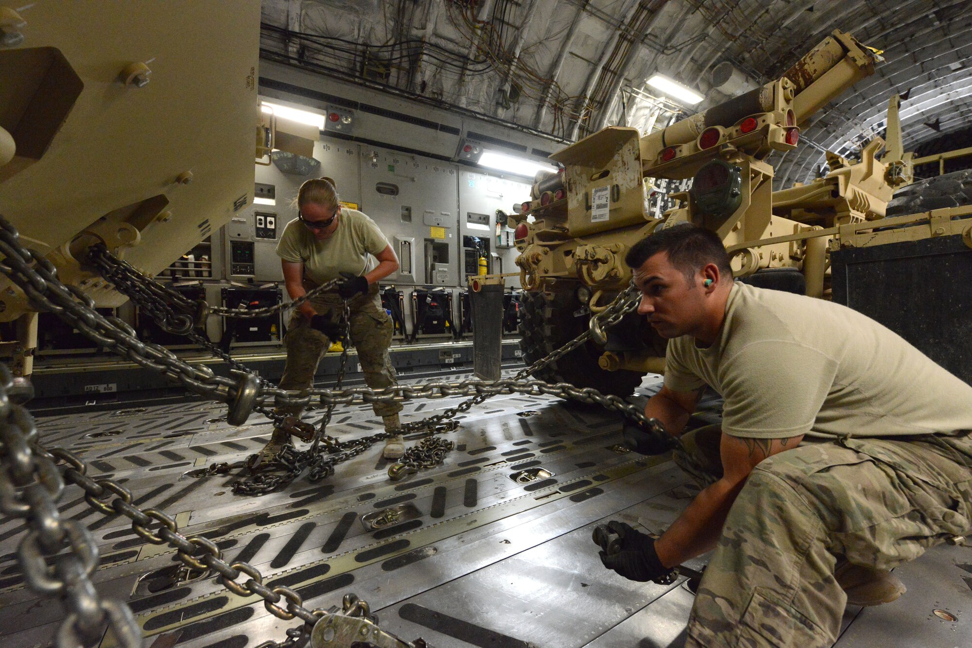 U.S. Air Force Master Sgt. Jessica Mallet, 455th Expeditionary Aerial Port Squadron Detachment 1 chief, and Staff Sgt. Reuben Montes, an air transportation journeyman, work together to secure armored vehicles aboard a C-17 Globemaster III while at Mazar-e Sharif, Afghanistan June 24, 2014. As part of the retrograde mission, EAPS Det 1 is responsible for inspecting and loading cargo and vehicles leaving Mazar-e Sharif. Mallett, a native of Clarksville, Tenn., is deployed from the 735th Air Mobility Squadron, Joint Base Pearl Harbor-Hickam, Hawaii, while Montes is a native of Worthington, Ohio and deployed from the 375th Logistics Readiness Squadron, Scott Air Force Base, Ill. (U.S. Air Force photo by Master Sgt. Cohen A. Young/Released)  
