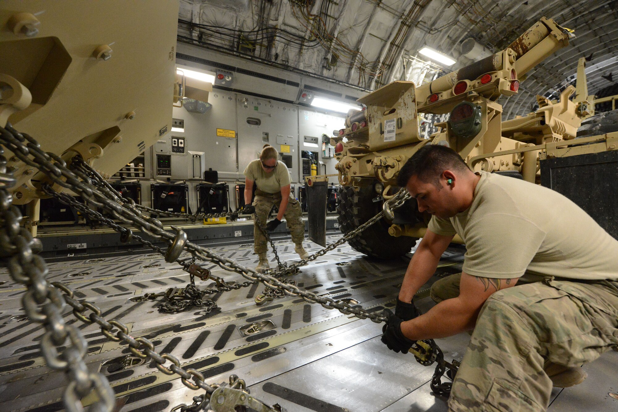 U.S. Air Force Master Sgt. Jessica Mallet, 455th Expeditionary Aerial Port Squadron Detachment 1 chief, and Staff Sgt. Reuben Montes, an air transportation journeyman, work together to secure armored vehicles aboard a C-17 Globemaster III while at Mazar-e Sharif, Afghanistan June 24, 2014. As part of the retrograde mission, EAPS Det 1 is responsible for inspecting and loading cargo and vehicles leaving Mazar-e Sharif. Mallett, a native of Clarksville, Tenn., is deployed from the 735th Air Mobility Squadron, Joint Base Pearl Harbor-Hickam, Hawaii, while Montes is a native of Worthington, Ohio and deployed from the 375th Logistics Readiness Squadron, Scott Air Force Base, Ill. (U.S. Air Force photo by Master Sgt. Cohen A. Young/Released)  