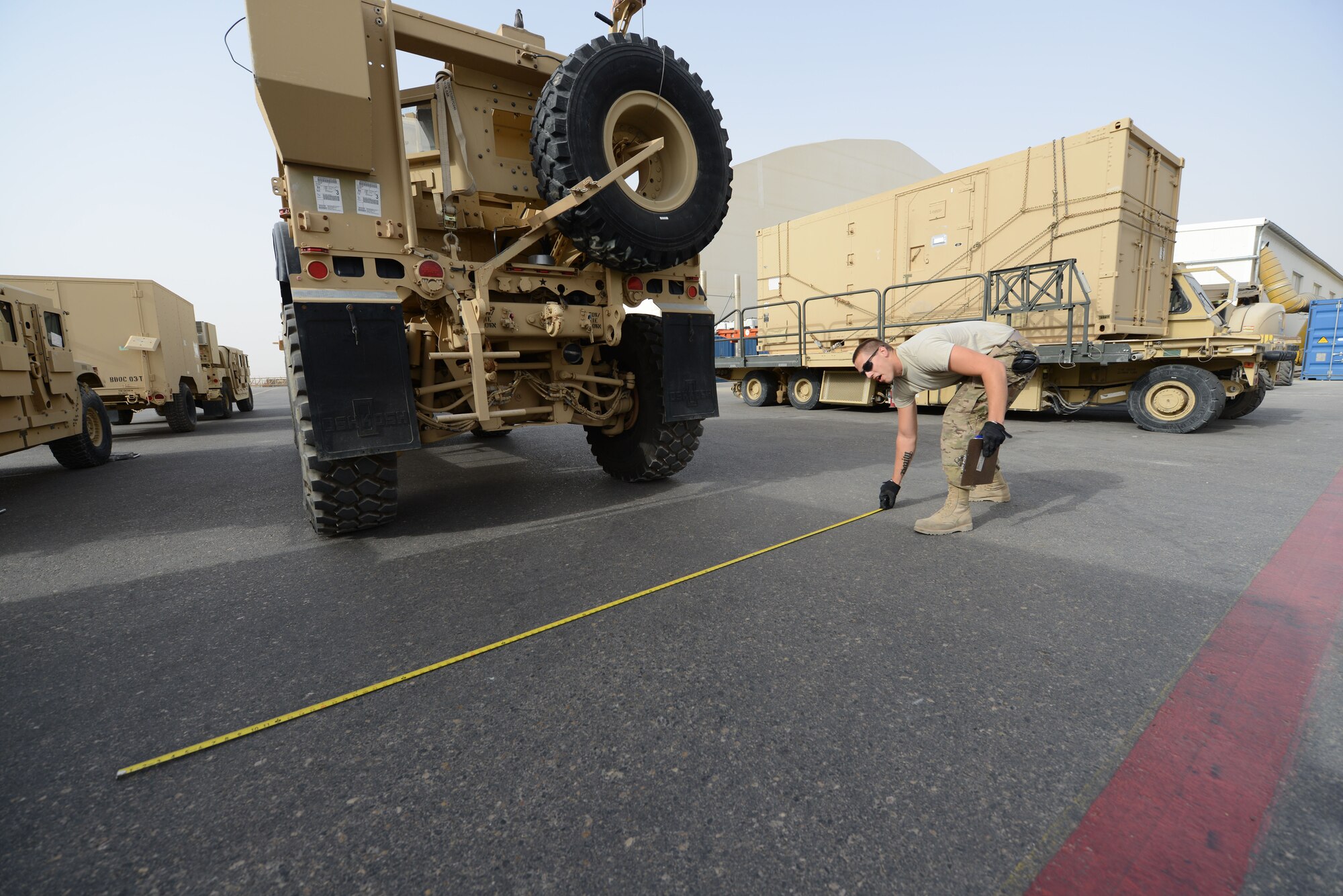 U.S. Air Force Tech. Sgt. Chaz Jensby, a night shift supervisor assigned to the 455th Expeditionary Aerial Port Squadron Detachment 1, measures the width of a Mine Resistant Ambush Protected All-Terrain Vehicle as part of inspection procedures at Mazar-e Sharif, Afghanistan June 24, 2014. Before accepting vehicles for shipment, Jensby is responsible for ensuring the weight matches the shipping paperwork and the vehicles are cleaned. If these aren’t done, the vehicle is returned to the customer. Jensby, a native of Lincoln, Neb., is a reservist deployed from the 155th Air Refueling Wing, Lincoln, Neb. (U.S. Air Force photo by Master Sgt. Cohen A. Young/Released)  