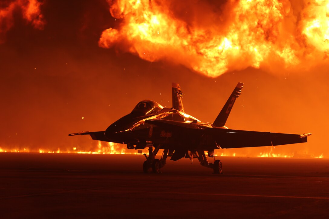 Flames explode behind the U.S. Navy Blue Angels'  F/A-18 Hornets during the night portion of the 2014 Miramar Air Show aboard Marine Corps Air Station Miramar, Calif., Oct. 4. The wall of fire is the last event of the night air show.