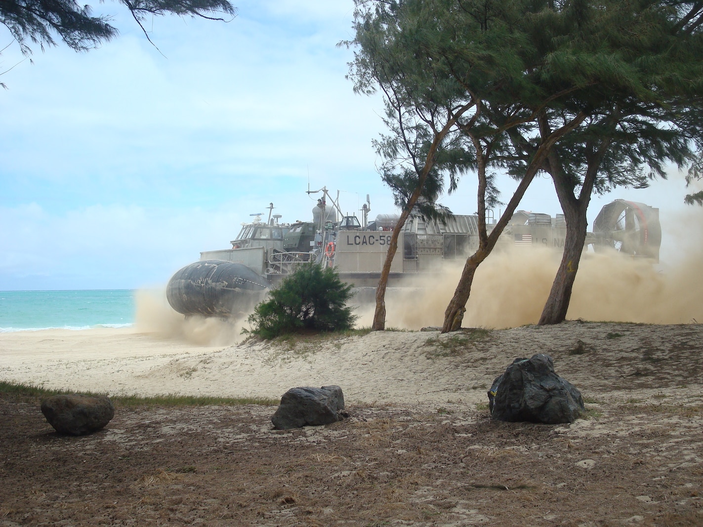 An LCAC with vehicles from Battery R lands on the beach at MCTAB, Oahu, Hawaii on 14 July 2014.