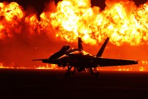 Flames explode behind the U.S. Navy Blue Angels'  F/A-18 Hornets during the night portion of the 2014 Miramar Air Show aboard Marine Corps Air Station Miramar, Calif., Oct. 4. The wall of fire is the last event of the night air show.