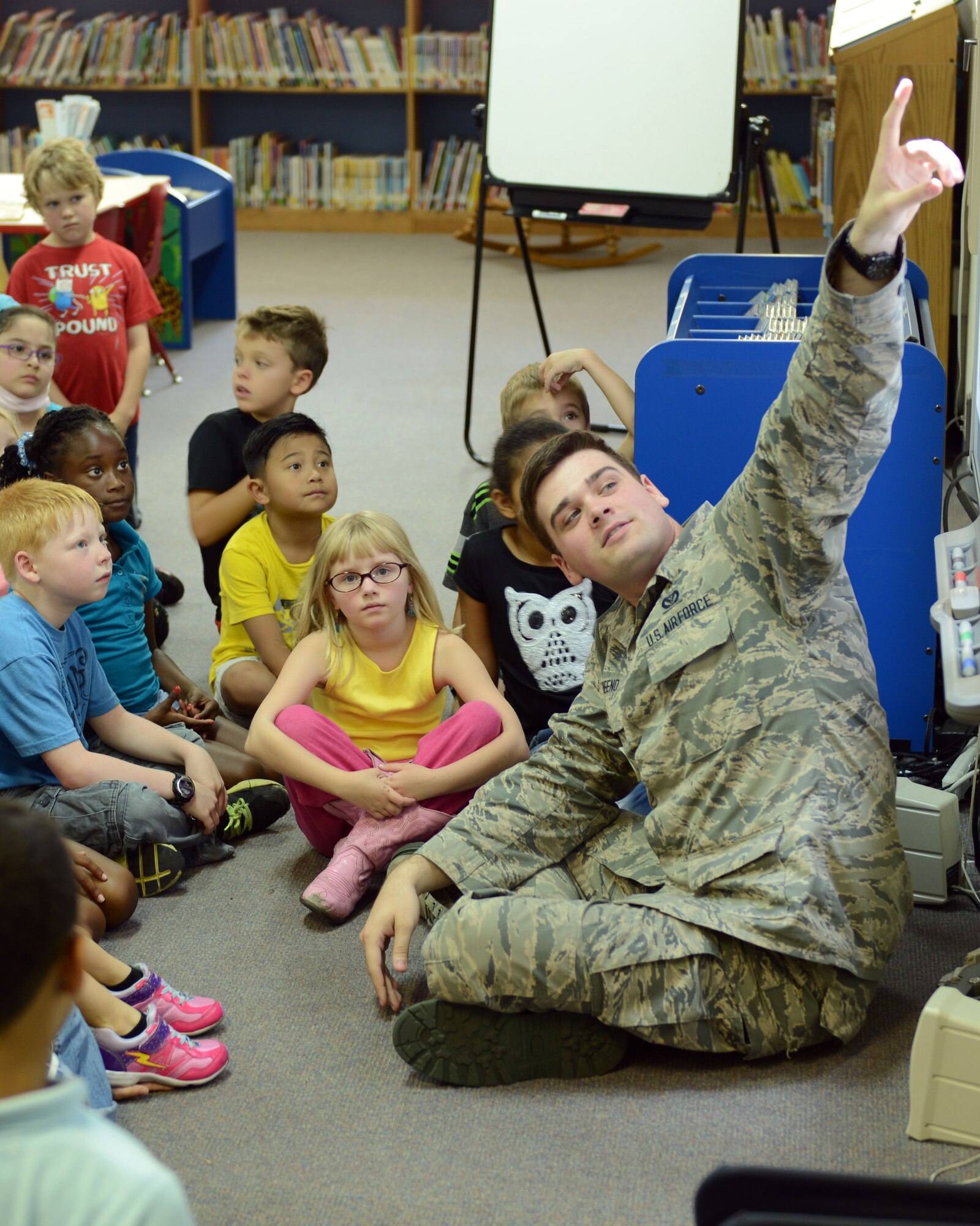 Airman 1st Class Christopher Greeno, 374th Civil Engineer Squadron logistics apprentice, points out pictures of natural disasters on a screen to children at Yokota West Elementary school Sept. 30, 2014, at Yokota Air Base, Japan. Greeno and other members from the 374 CES educated the children on potential disasters they could encounter while living at Yokota. (U.S. Air Force photo by Senior Airman Desiree Economides/Released)