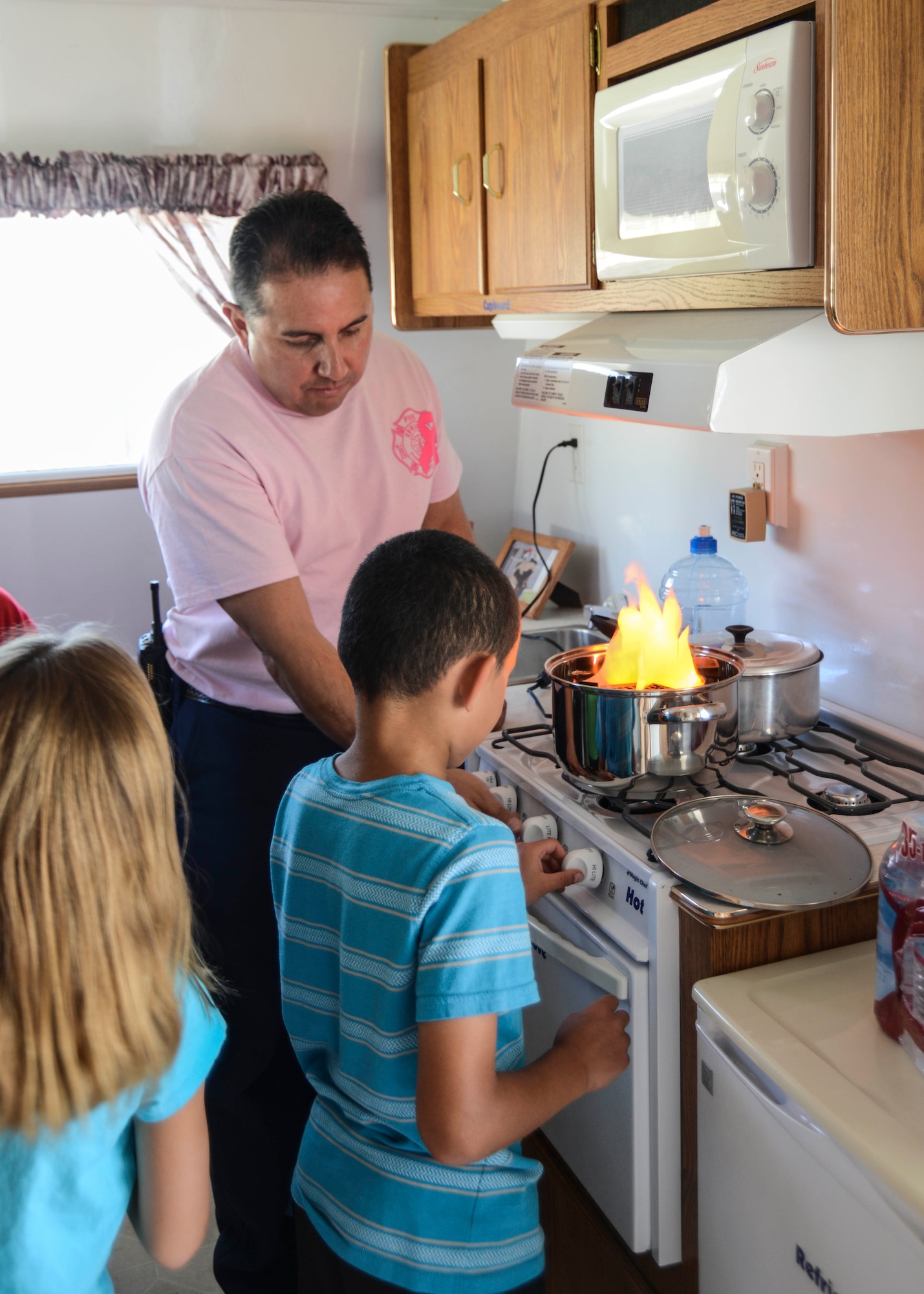 Students at Branch Elementary were taught about fire prevention and safety in the Fire Safety Trailer, which simulates fire hazards in the home. In the kitchen a simulated grease fire is used to teach children how to react by covering the fire with a lid. (U.S. Air Force photo by Rebecca Amber)