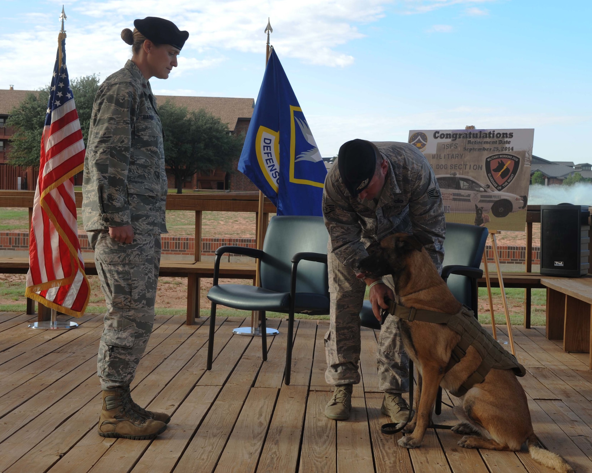 U.S. Air Force Staff Sgt. Sean Davis, 7th Security Forces Squadron, military working dog (MWD) handler removes FForde’s MWD badge to relinquish his duties, Sept. 25, 2014, at Dyess Air Force Base, Texas. FForde served as a MWD for eight years, which included four deployments where he provided improvised detection capabilities and security. (U.S. Air Force photo by Airman 1st Class Autumn Velez/Released)