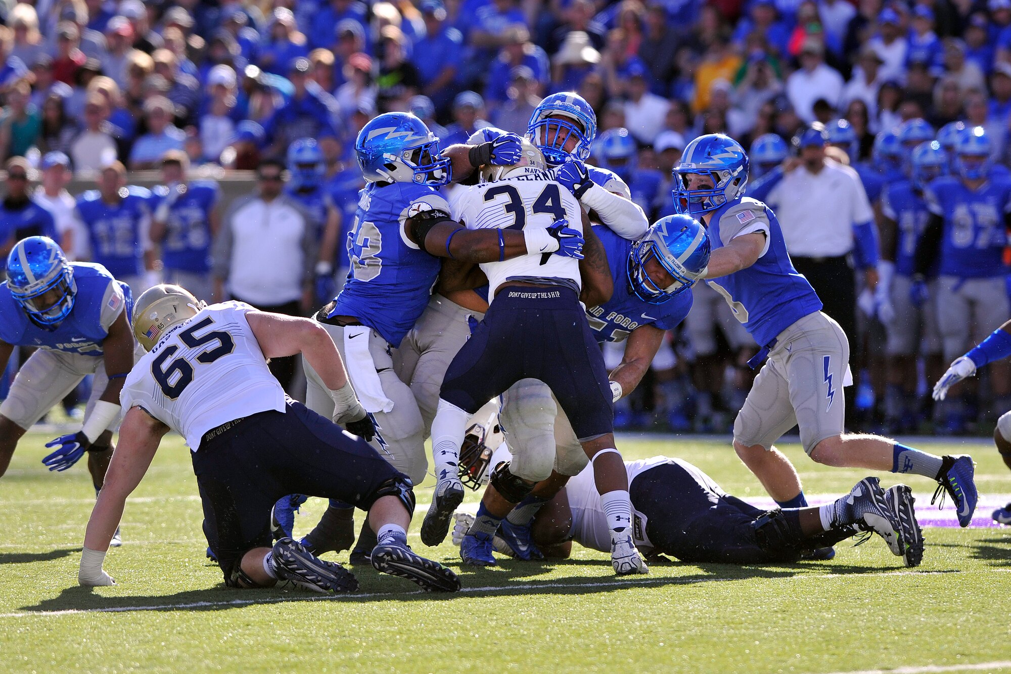 Falcon Football players take down Navy Midshipman senior fullback and co-captain Noah Copeland here Oct. 4. Air Force beat Navy 30-21 in a contest putting Air Force just one win away from the Commander-in-Chief's Trophy, awarded to the service academy football team that defeats it's military rivals. (U.S. Air Force photo/Jason Gutierrez) 