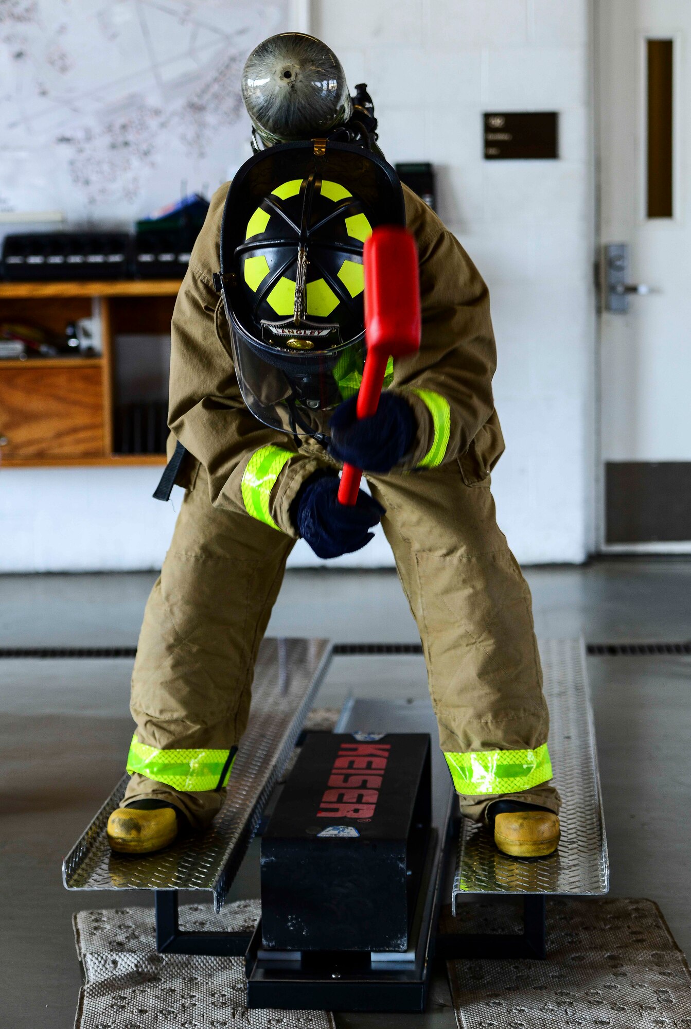 U.S. Air Force Airman 1st Class Scott Kolar, 633rd Civil Engineer Squadron firefighter, uses a 10-pound hammer to move a 160-pound sled during a firefighter challenge at Langley Air Force Base, Va., Oct. 1, 2014. In the sixth year of the challenge, 59 firefighters were tested on their strength and stamina as they completed essential tasks used for fighting fires. (U.S. Air Force photo by Senior Airman Kayla Newman/Released)