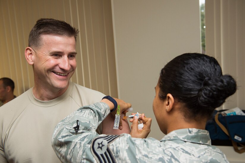 Chief Master Sgt. Mark Bronson, 628th Air Base Wing command chief, receives his seasonal flu shot Oct. 7, 2014, at Joint Base Charleston, S.C. Flu shots are now available for all active-duty service members and children at the 628th Medical Group. (U.S. Air Force photo/Senior Airman George Goslin)