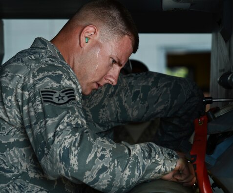 Sweat drips down the face of U.S. Air Force Staff Sgt. Randy Therriault, 20th Aircraft Maintenance Squadron weapons load crew chief, with the Gamblers Aircraft Maintenance Unit, while he attaches an MK-82 slick missile to an F-16CM Fighting Falcon during a load crew competition at Shaw Air Force Base, S.C., Oct. 3, 2014. The winner of the weapons load crew competition will be released at the next 20th Maintenence Group quarterly awards banquet. (U.S. Air Force photo by Senior Airman Tabatha Zarrella/Released)