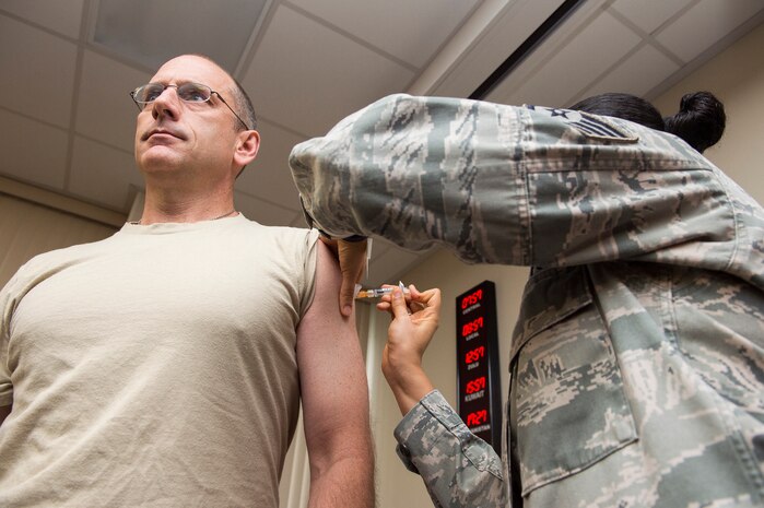 Col. Scott Sauter, 315th Airlift Wing commander, receives his seasonal flu shot Oct. 7, 2014, at Joint Base Charleston, S.C. Flu shots are now available for all active-duty service members and children at the 628th Medical Group. (U.S. Air Force photo/Senior Airman George Goslin)