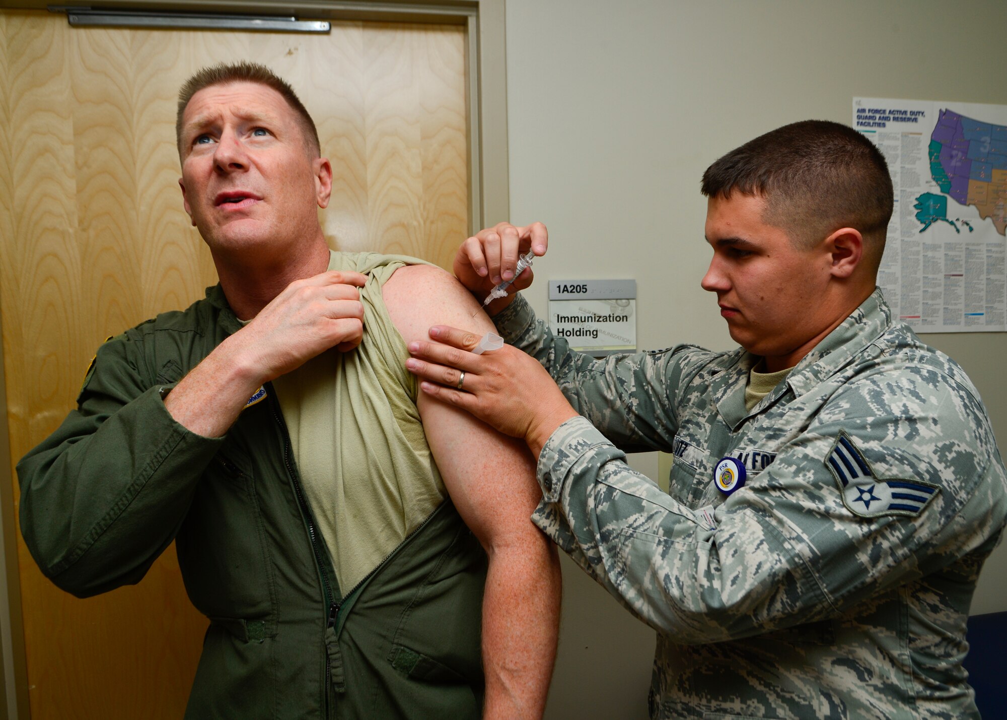 Col. Michael Grismer, 436th Airlift Wing commander, receives his annual influenza shot from Senior Airman Jeffrey Utz, 436th Medical Operations Squadron allergy and immunizations technician, Aug. 6, 2014, at the 436th Immunizations Clinic on Dover Air Force Base, Del. The clinic administered more than 6,000 flu vaccines to active duty, retirees and dependents. (U.S. Air Force photo/Airman 1st Class William Johnson)