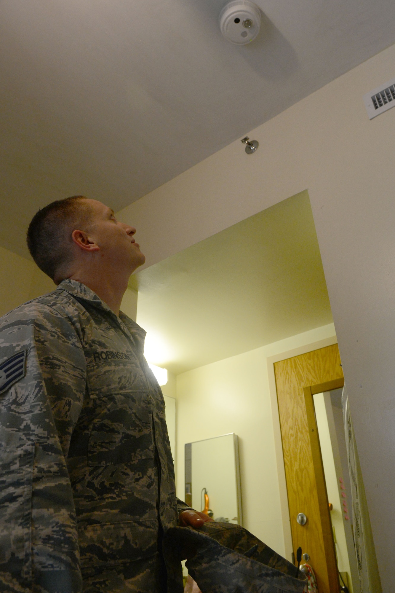 U.S. Air Force Staff Sgt. Matthew Robinson, 20th Civil Engineer Squadron Airman dormitory leader checks the smoke detector inside a dorm to ensure it is operational after being replaced at Shaw Air Force Base, S.C., Oct. 3, 2014. One of the primary duties of dorm management is to ensure everything is functioning properly for dorm residents. (U.S. Air Force photo by Senior Airman Ashley L. Gardner/Released)