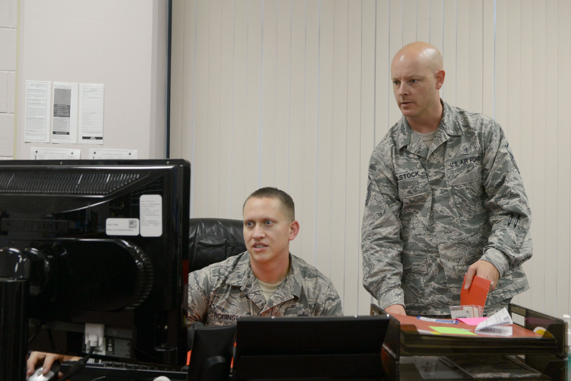 U.S. Air Force Staff Sgt. Matthew Robinson, 20th Civil Engineer Squadron Airman dormitory leader, and Master Sgt. Brian Ailstock, 20th CES section chief of unaccompanied housing, check to see which rooms are available to be assigned to new Airmen at Shaw Air Force Base, S.C., Oct. 3, 2014. The amount of Airmen coming from technical training school causes the operation tempo of the office to speed up. (U.S. Air Force photo by Senior Airman Ashley L. Gardner/Released)