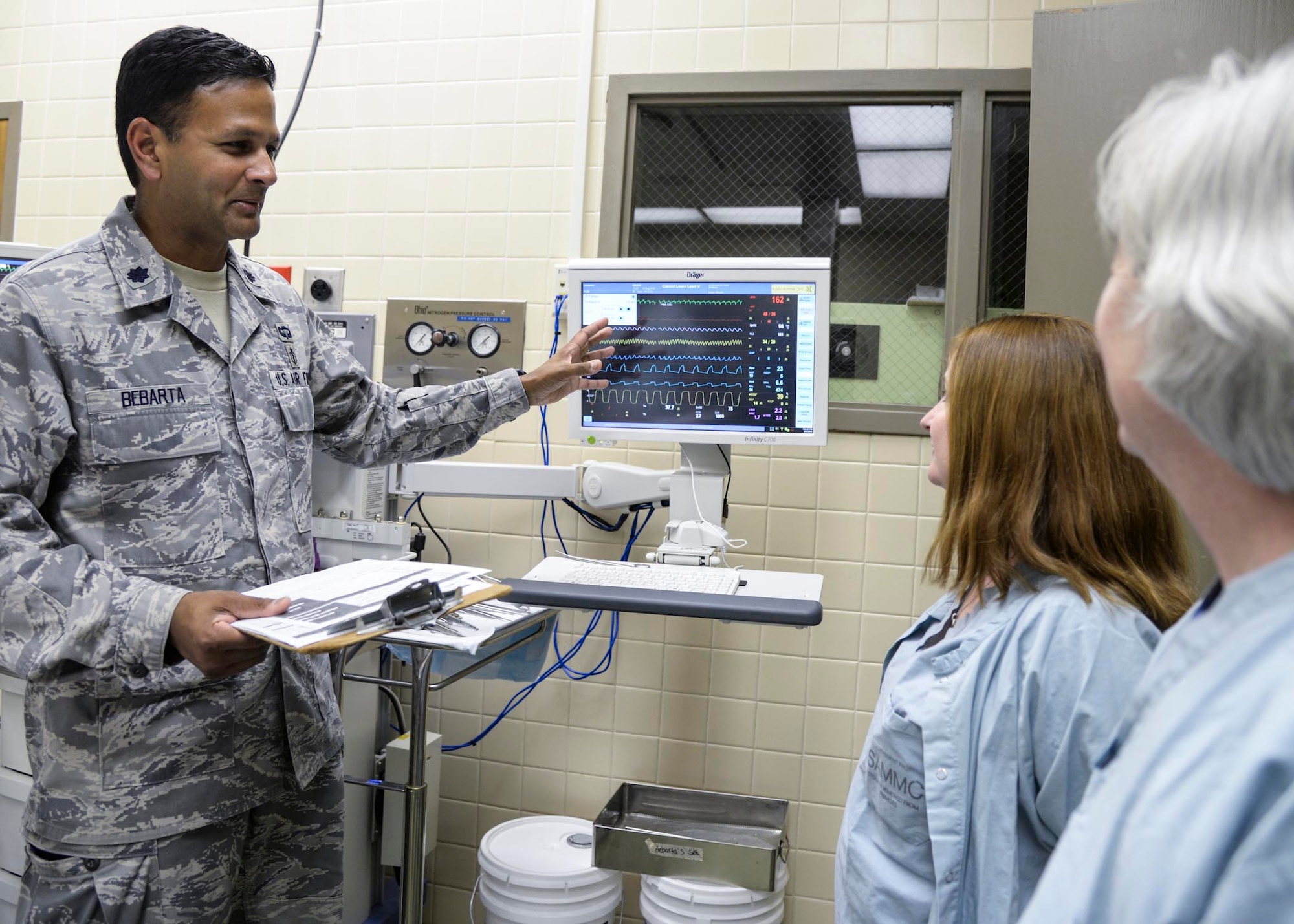 Air Force Lt. Col. Vikhyat Bebarta, director of the 59th Medical Wing En Route Care Research Center (ECRC) and chief of medical toxicology at the San Antonio Military Medical Center on nearby Joint Base San Antonio-Fort Sam Houston, reviews statistics with fellow research technicians at the Wilford Hall Ambulatory Surgical Center, Joint Base San Antonio-Lackland, Texas, Aug. 12. Bebarta garnered the Gen. Paul W. Myers award and the National Society for Academic Emergency Medicine Basic Science award. (U.S. Air Force photo/Staff Sgt. Kevin Iinuma)