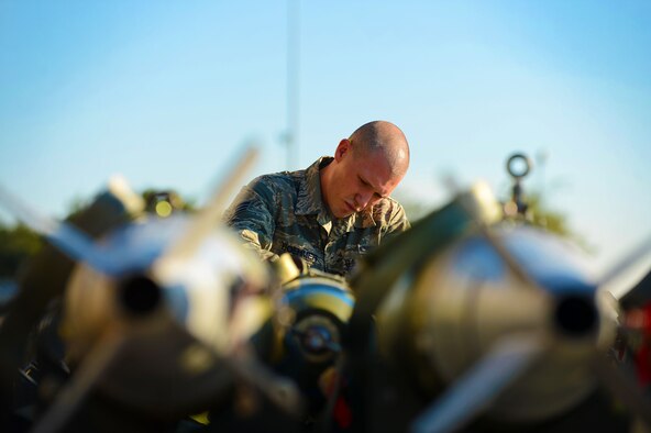 U.S. Air Force Senior Airman Timothy Boehmer, 20th Equipment Maintenance Squadron weapons load crew member, prepares an MK-82 slick missile at Shaw Air Force Base, S.C., Oct. 3, 2014. Boehmer helped his team prepare six missiles before putting them onto a bomb loader during a load crew of the quarter competition. (U.S. Air Force photo by Airman 1st Class Jensen Stidham/Released)
