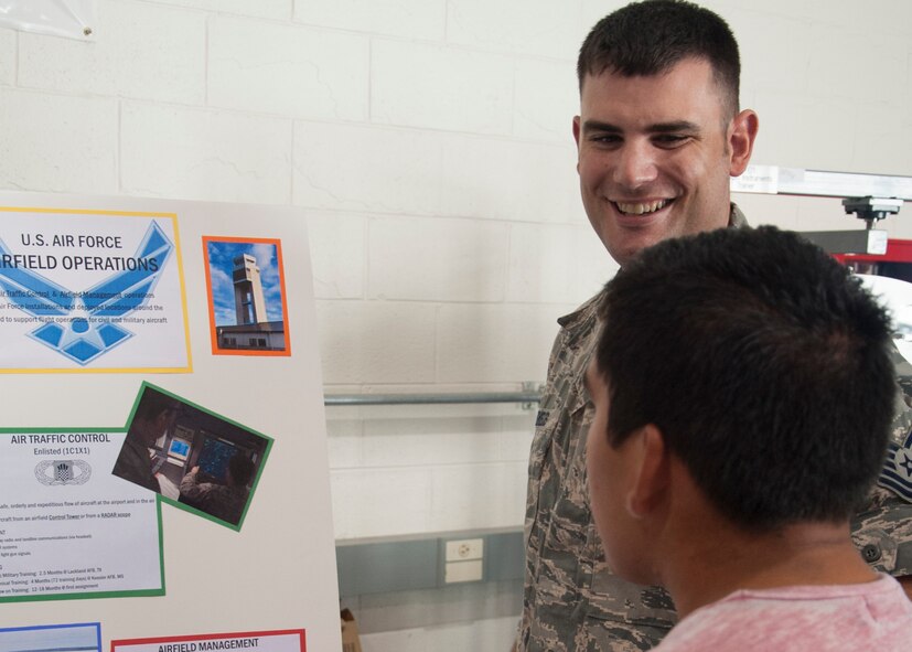 Tech. Sgt. Ricardo Reveles, 436th Operations Support Squadron radar approach controller, talks with a student from a local high school about his job duties during the Aviation Education Day October 3, 2014, at the Sussex County Airport in Georgetown, Del.  Students in high school used the day to talk with representatives from different aviation agencies about pursuing careers in the field. (U.S. Air Force photo/Senior Airman Jared Duhon)