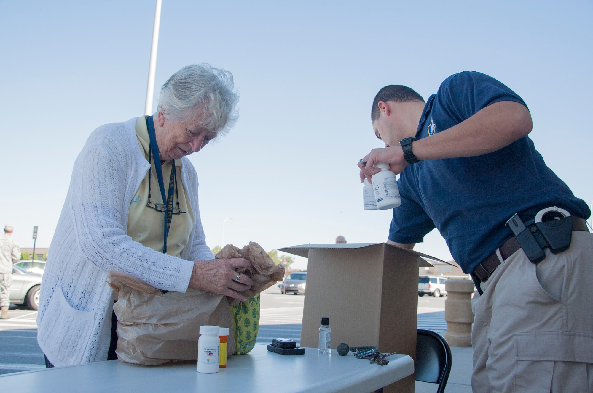 Joan Edwards, a local retiree, and Staff Sgt. Dan Gauer, 436th Security Forces Squadron investigator, place unused medicine in a box Sept. 27, 2014, in front of the commissary on Dover Air Force Base, Del. The medicine was brought to the commissary as part of National Drug Take Back Day with support from the Drug Enforcement Administration, the 436th SFS and the 436th Medical Support Squadron pharmacy. Nine boxes were gathered weighing in at a total of 175.2 pounds. (U.S. Air Force photo/Senior Airman Jared Duhon) 