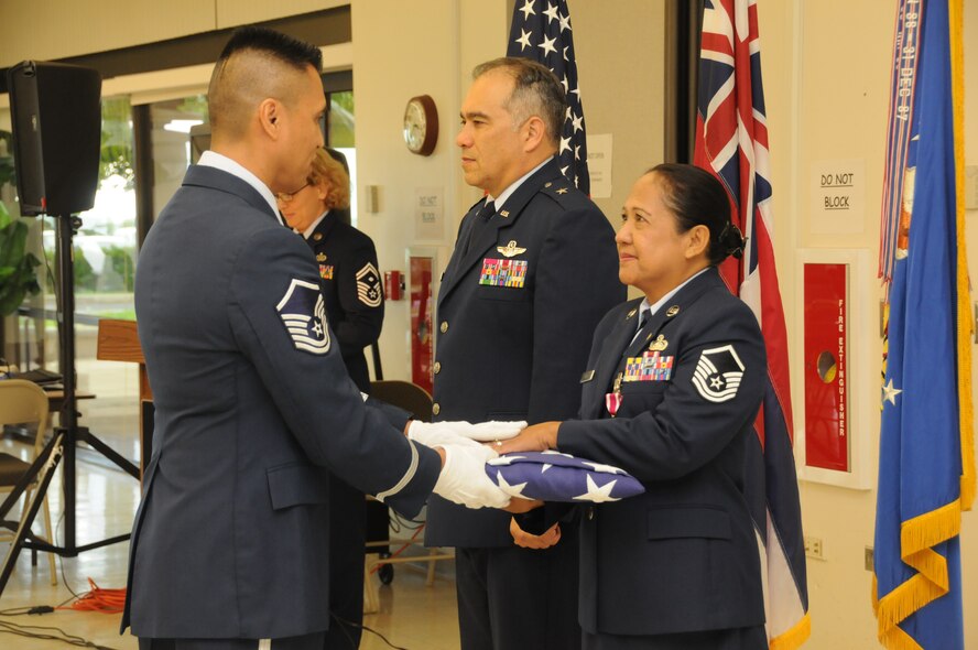 U.S. Air Force Honor Guard presents Master Sgt. Glenda Buis, Executive Administrative Assistant at the 154th Wing, with her retirement flag during Buis' retirement ceremony on Sept. 5, 2014 at Joint Base Pearl Harbor Hickam, Hawaii. (U.S. Air Force photo by Airman 1st Class Robert Cabuco)
