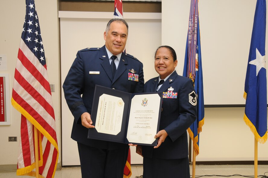 U.S. Air Force Brig. Gen. Braden Sakai, Commander 154th Wing, Hawaii Air National Guard, presents Master Sgt. Glenda Buis, Executive Administrative Assistant at the 154th Wing, with her certificate of retirement during Buis' retirement ceremony on Sept. 5, 2014 at Joint Base Pearl Harbor Hickam, Hawaii. (U.S. Air Force photo by Airman 1st Class Robert Cabuco)