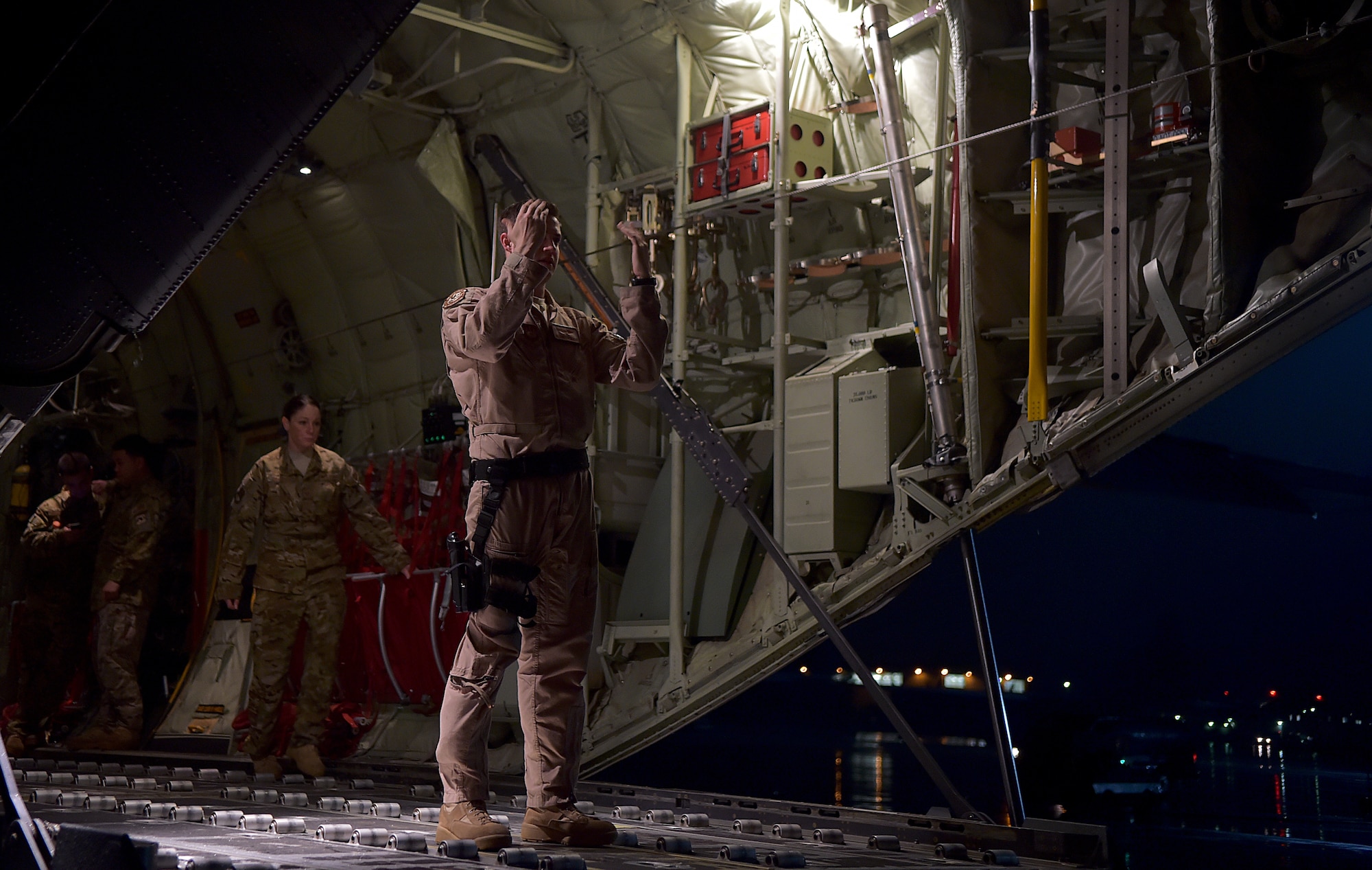 Senior Airman Christian McDevitt, load master with the 37th Airlift Squadron, leads a cargo loader to a C-130-J Super Hercules prior to a mission in support of the Ebola virus epidemic, Oct. 7, 2014, at Ramstein Air Base, Germany. As the Ebola outbreak becomes a potential global threat, U.S. Africa Command is working in support of the U.S. Agency for International Development, the lead federal agency (LFA), as part of a comprehensive U.S. Government effort to respond to and contain the outbreak of the Ebola virus in West Africa as quickly as possible.  This was the first C-130J Super Hercules flight launched from Ramstein to Monrovia, Liberia in support of Operation UNITED ASSISTANCE. (U.S. Air Force photo by/Staff Sgt. Sara Keller)