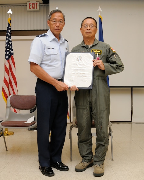 U.S. Air Force Maj. Gen. Daryll DM Wong, Adjutant General, State of Hawaii, presents Col. Richard E Ando, State Air Surgeon, Hawaii Air National Guard, with a certificate of retirement on Sept. 4, 2014 at Joint Base Pearl Harbor Hickam, Hawaii. Col. Ando also serves the community as a doctor specializing in allergy and immunology at the Kuakini Medical Center. (U.S. Air Force photo by Airman 1st Class Robert Cabuco)