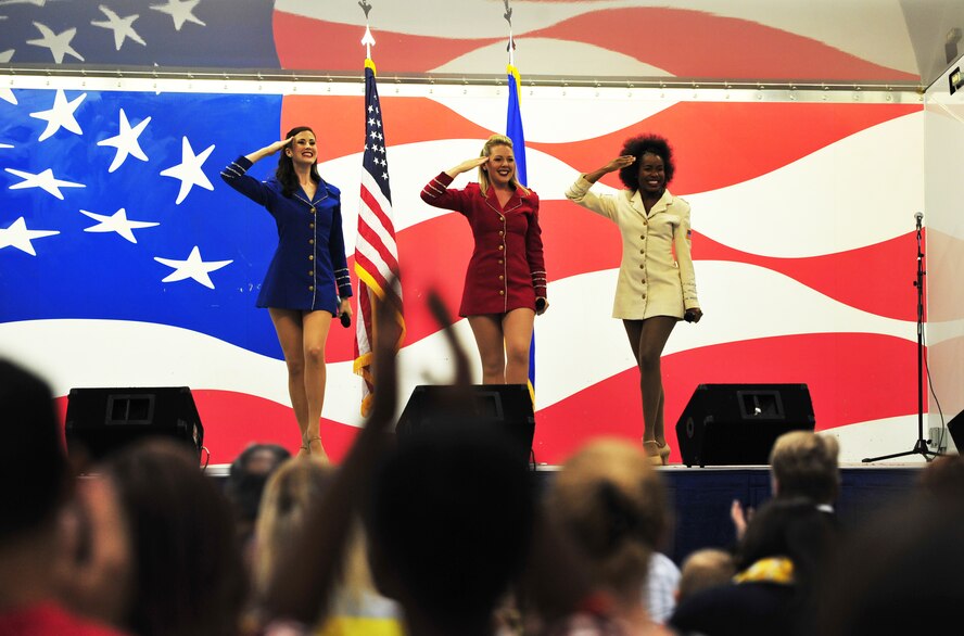 Performers from the United Service Organizations Show Troupe render a salute during a performance at Seymour Johnson Air Force Base, North Carolina, Oct. 3. The Show Troupe, made up of five singers and a support team, provided an hour-long set for members of Team Seymour. They annually perform musical entertainment for more than 600,000 service members and families across the globe. (U.S. Air Force photo/Senior Airman John Nieves Camacho)