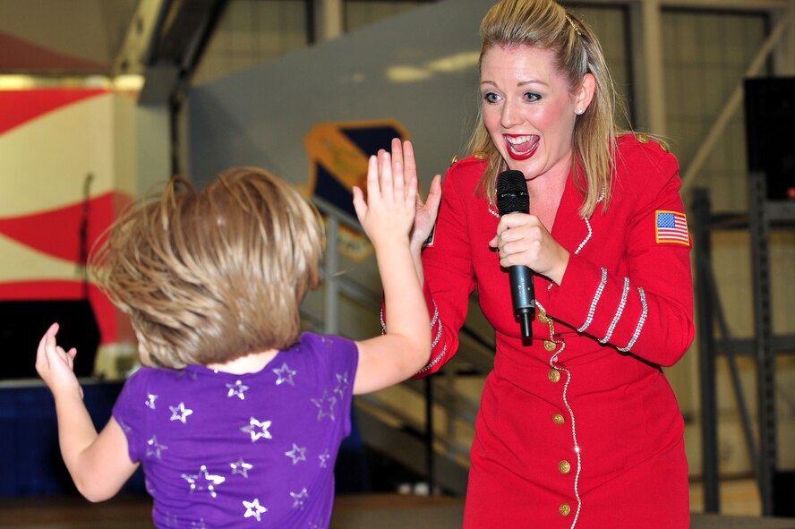 Stephanie Gerson, United Service Organizations Show Troupe performer, gives a high-five to one of Team Seymour’s littlest members during a performance at Seymour Johnson Air Force Base, North Carolina, Oct. 3. The Show Troupe, made up of five singers and a support team, provided an hour-long set. They annually perform musical entertainment for more than 600,000 service members and families across the globe. (U.S. Air Force photo/Senior Airman John Nieves Camacho)