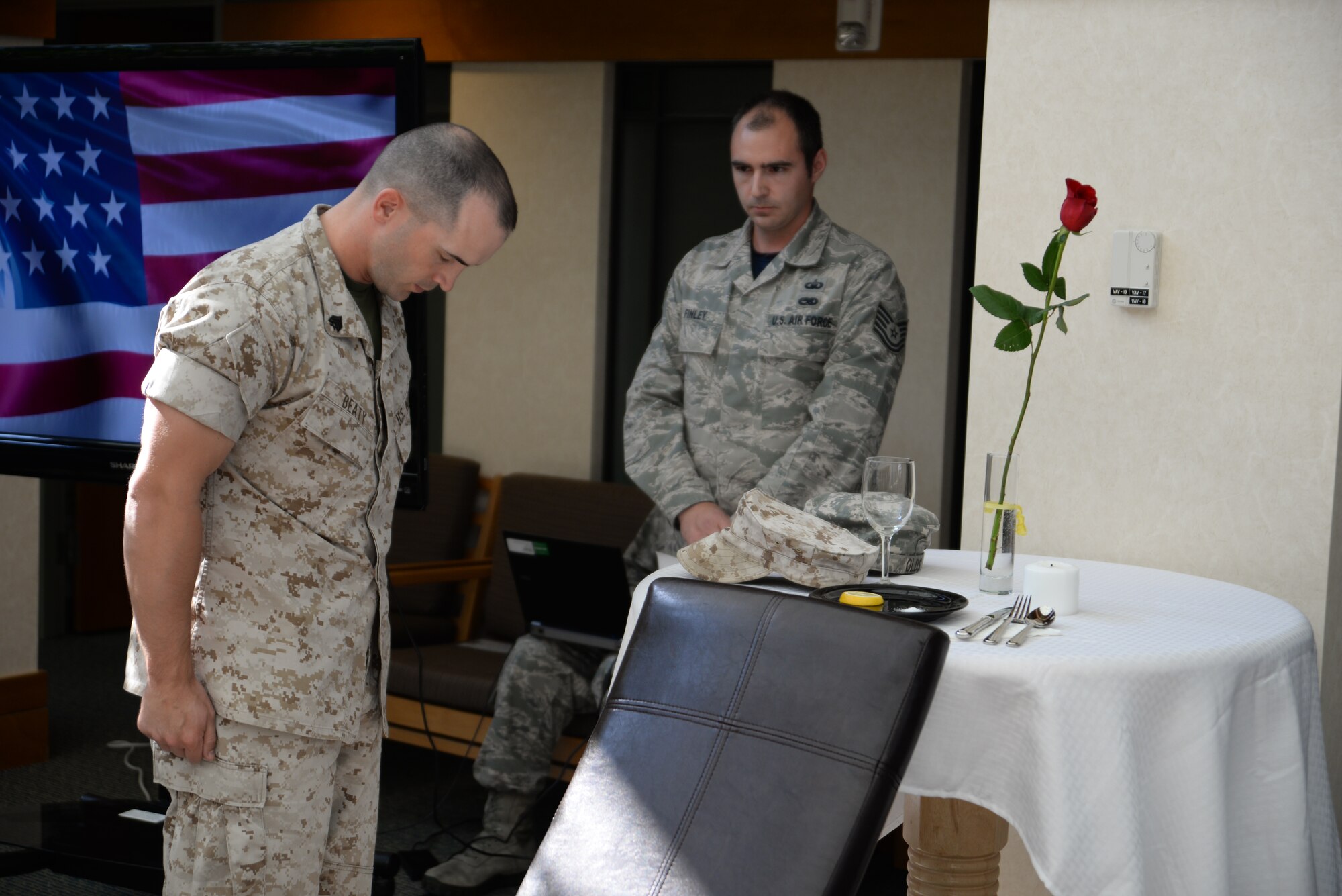 Marine Corps Sgt. Landon Beaty pays his respects after he places his cover on the POW/MIA table during a remembrance ceremony in the atrium of the Charles C. Carson Center for Mortuary Affairs, Dover Air Force Base, Del., Sept. 19, 2014. A representative from each service placed a hat representing their service in honor of all those still missing in action. Beaty, a former liaison at the mortuary is assigned to Marine Corps Station Quantico, Va. (U.S. Air Force photo/Master Sgt. Chris Gish)