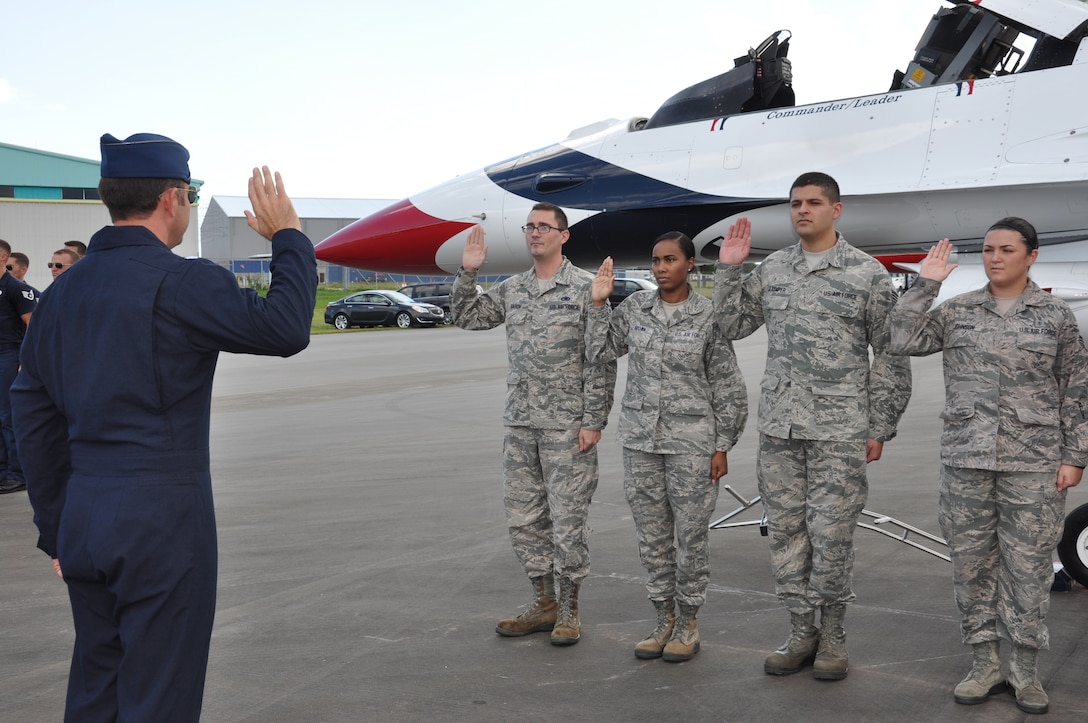 Lt. Col. Greg Moseley, U.S. Air Force Thunderbird commander, (left) administers the oath of enlistment to members of the 45th Space Wing and Air Force Technical Applications Center, Oct. 3, 2014, as part of the events leading up to the Melbourne Air & Space Show, Melbourne, Fla. In attendance were friends and family who were invited by the Thunderbirds to watch their practice performance, which took off immediately following the reenlistment ceremony.  (U.S. Air Force photo/Shawn M. Walleck) (Released)