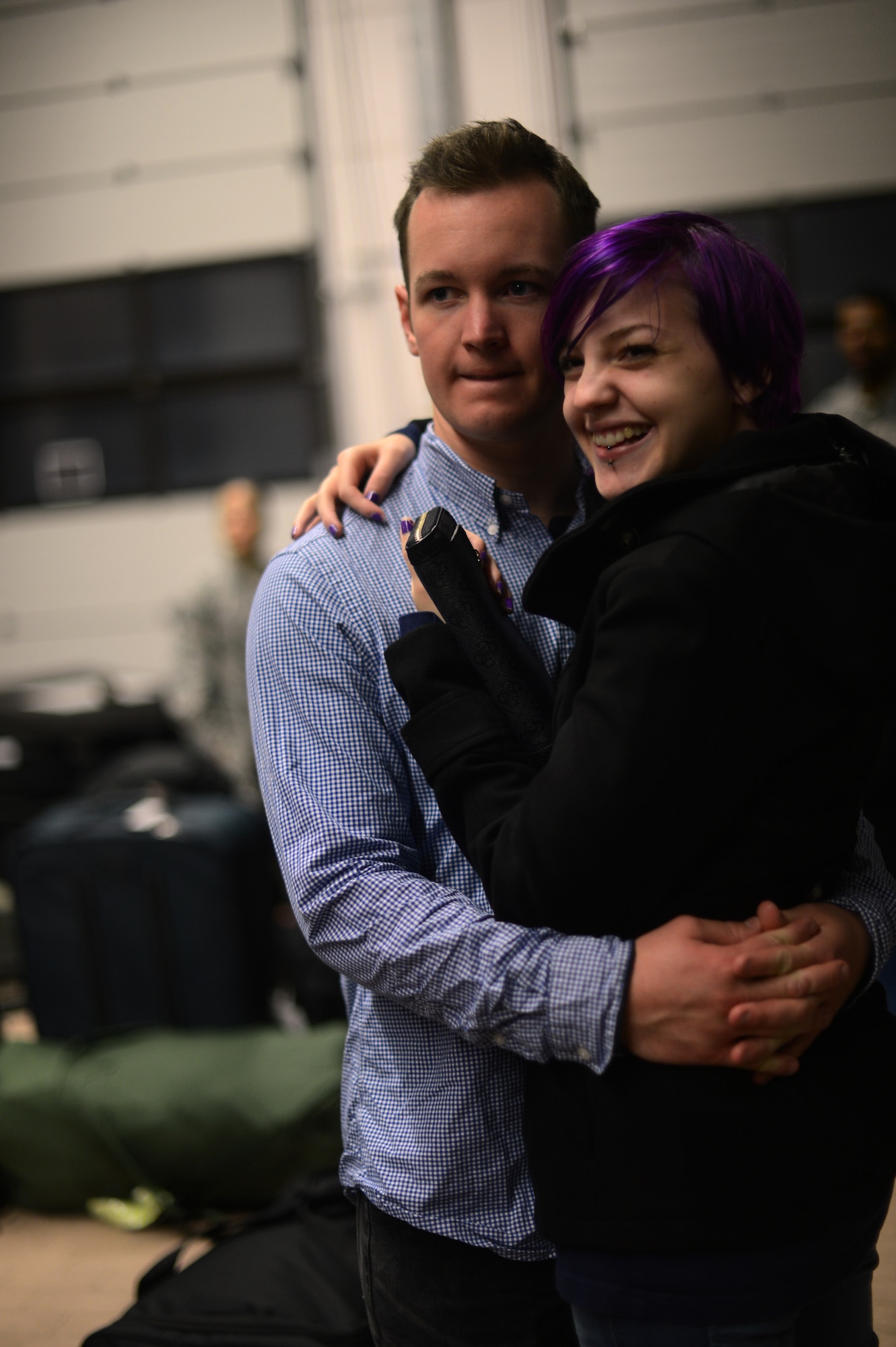 U.S. Air Force Senior Airman Julian Chesser, a 606th Air Control Squadron interface control technician and native of Prattville, Ala., left, embraces his fiancée, Kessia Unger, on Spangdahlem Air Base, Germany, Oct. 7, 2014, before departing for a deployment to an undisclosed location in Southwest Asia. More than 300 friends, family and members of the 606th ACS gathered to see off their loved ones. (U.S. Air Force photo by Senior Airman Gustavo Castillo/Released)