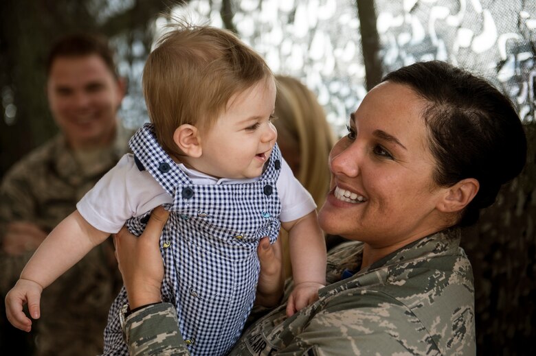 U.S. Air Force Staff Sgt. Lauren Duran, 606th Air Control Squadron assistant NCO in charge of training from Nashville, Tenn., holds 9 month-old Clay Burch, son of Tech. Sgt. Robert Burch, during a barbecue Sept. 19, 2014, at Spangdahlem Air Base, Germany. The squadron hosted the event for Airmen and families to get together before a deployment. (U.S. Air Force photo by Senior Airman Rusty Frank/Released)