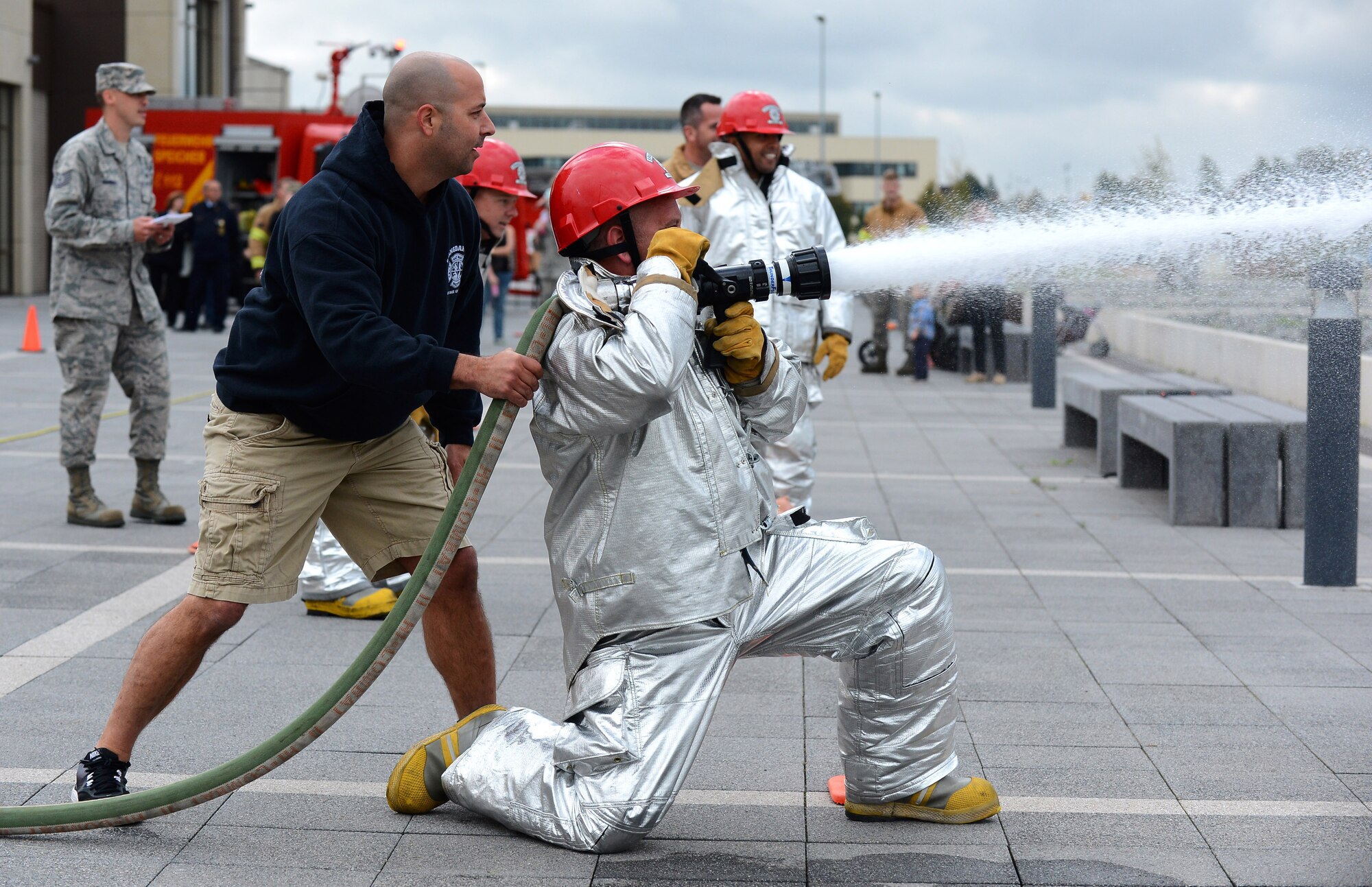 U.S. Air Force Master Sgt. Martin P. Lerch, 52nd Force Support Squadron first sergeant and native of Fullerton, Calif., aims a fire hose at a target during a Fire Muster Challenge at the Exchange parking lot on Spangdahlem Air Base, Germany, Oct. 6, 2014. The Fire Muster Challenge, sponsored by the 52nd Civil Engineer Squadron, tested teams of four on their ability to work together to complete tasks a fire fighter might encounter every day. (U.S. Air Force photo by Airman 1st Class Luke J. Kitterman/Released)