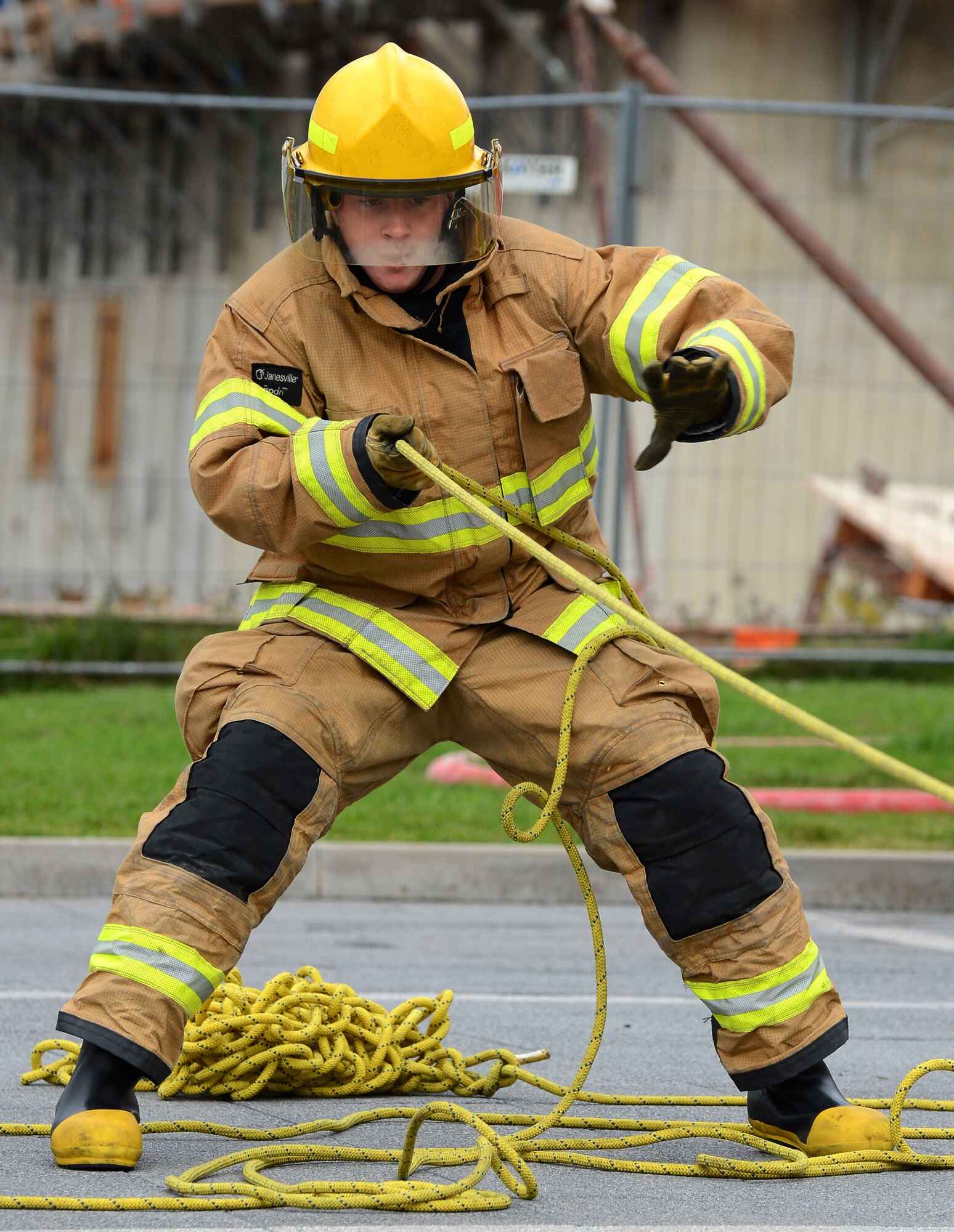 U.S. Air Force Airman 1st Class Alex J. Hein, 52nd Civil Engineer Squadron firefighter and native of Minerva, Ohio, reels in a rope during a Fire Muster Challenge at the Exchange parking lot at Spangdahlem Air Base, Germany, Oct. 6, 2014. Hein and his team of three other 52nd CES firefighters finished the challenge in less than five minutes. (U.S. Air Force photo by Airman 1st Class Luke J. Kitterman/Released)