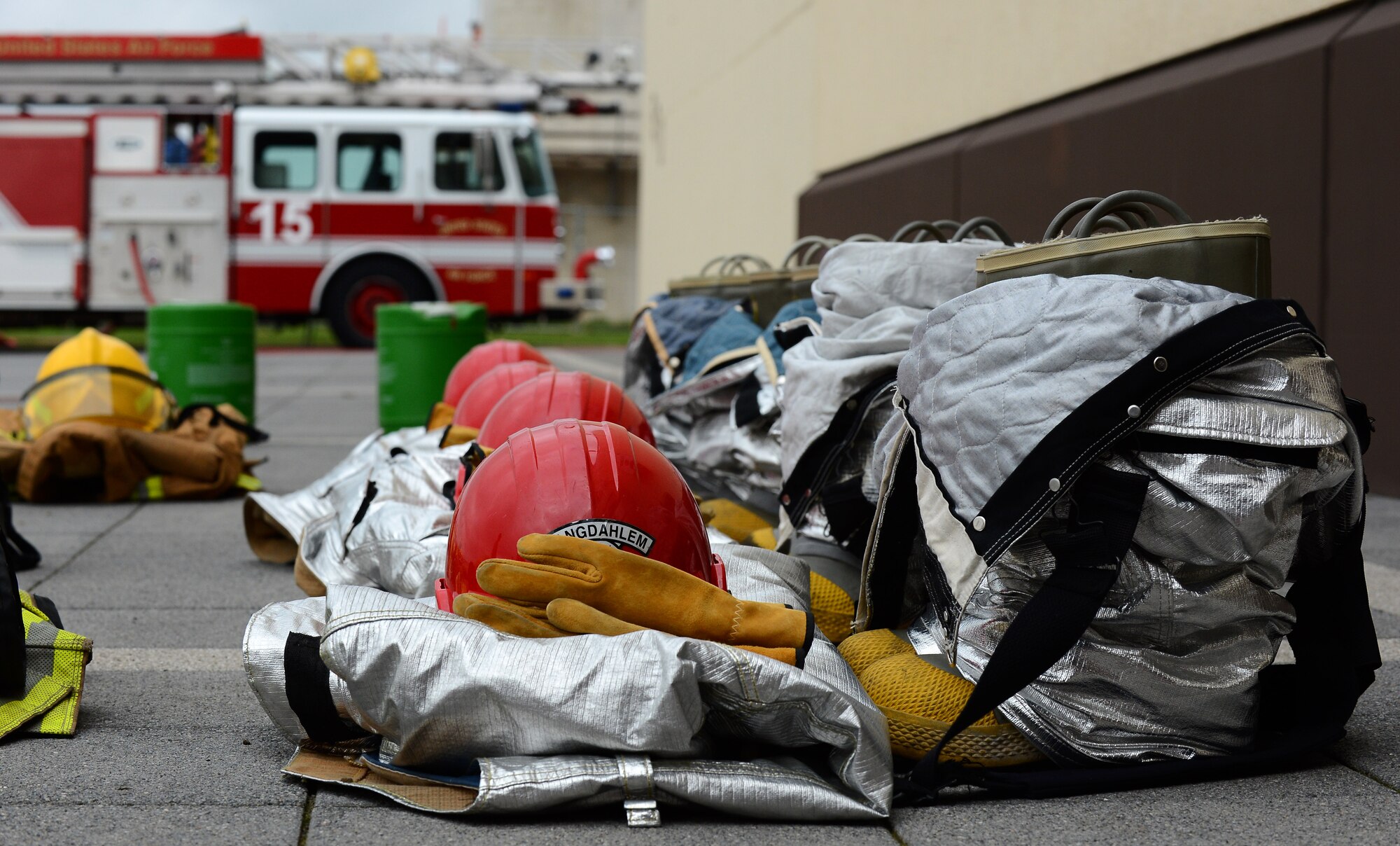 Firefighter gear rests on the ground during a Fire Muster Challenge at the Exchange parking lot at Spangdahlem Air Base, Germany, Oct. 6, 2014. The challenge included a 185-pound dummy drag, a rope pull and filling up a container with water one bucket at a time. (U.S. Air Force photo by Airman 1st Class Luke J. Kitterman/Released)