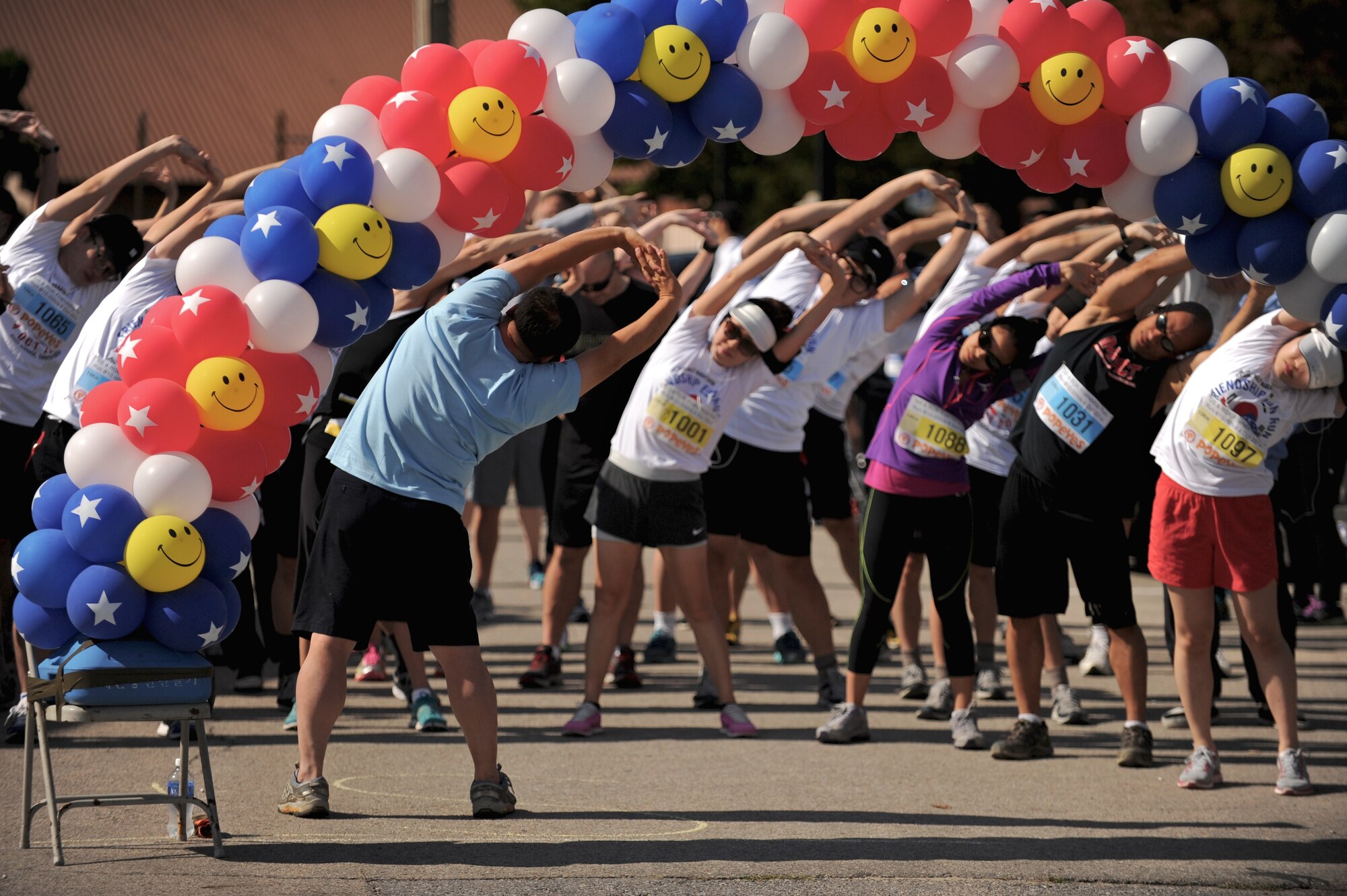 Moon, Hui Seong, one of over 50 volunteers, leads participants in stretches before a Friendship Fun Run Oct. 4, 2014 at Osan Air Base, Republic of Korea.  The run was hosted by the 607th Air Operations Center and its Good Neighbors.  More than 300 U.S. and Korean participants registered for the run.  (U.S. Air Force photo by Maj. John Ross)