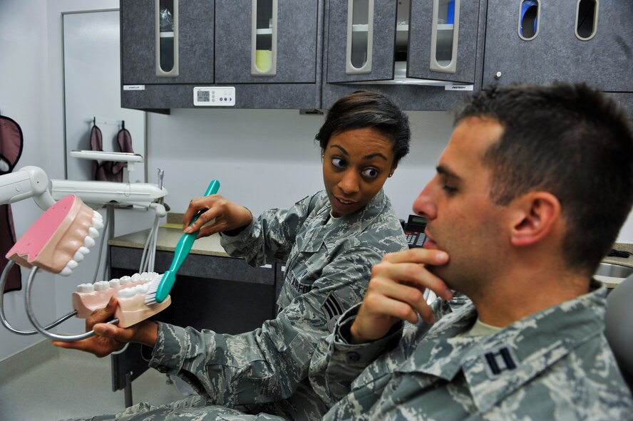 Senior Airman Micahela Kearse, 51st Dental Squadron dental technician, talks to a patient about properly brushing teeth during an annual dental examination Sept. 11, 2014, on Osan Air Base, Republic of Korea. Kearse is this week's Airman Spotlight winner. (U.S. Air Force photo by Senior Airman David Owsianka)