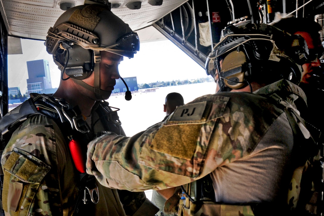 An Air Force pararescue jumpmaster checks an airman's equipment before participating in Soaring Angel 14 on Moffett Federal Airfield, Calif., Oct. 2, 2014. Soaring Angel 14 is a joint operation of tactical training and readiness requirements through multiple live scenarios in a simulated deployment environment. The pararescuemen are Guardian Angel Pararescue Team members assigned to the 129th Rescue Wing.
