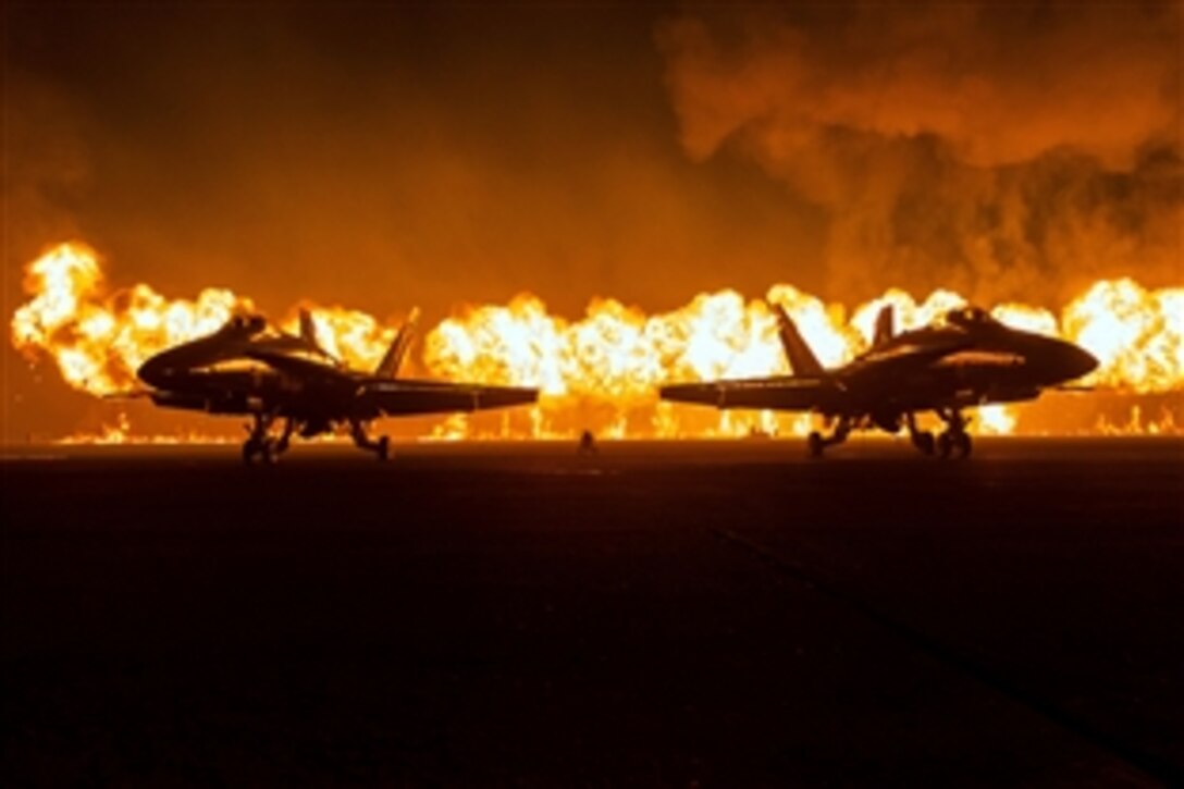 A wall of fire explodes behind the U.S. Navy Flight Demonstration Squadron, the Blue Angels, during the Marine Air Ground Task Force demonstration at the annual Miramar Air Show on Marine Corps Air Station Miramar, San Diego, Oct. 4, 2014.
